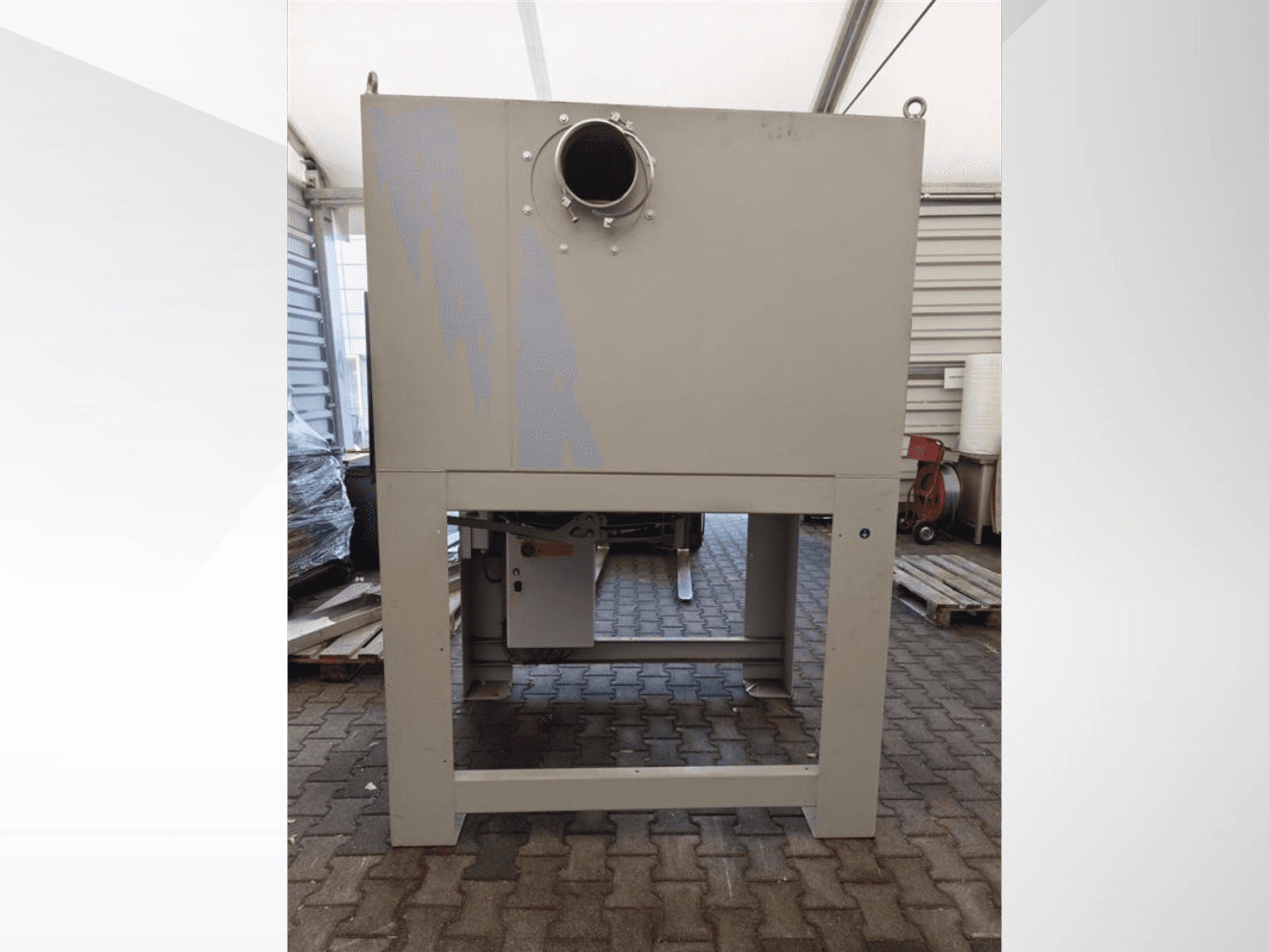 Szary odpylacz przemysłowy widziany z przodu, z dużym okrągłym otworem i zamontowany na solidnej podstawie.