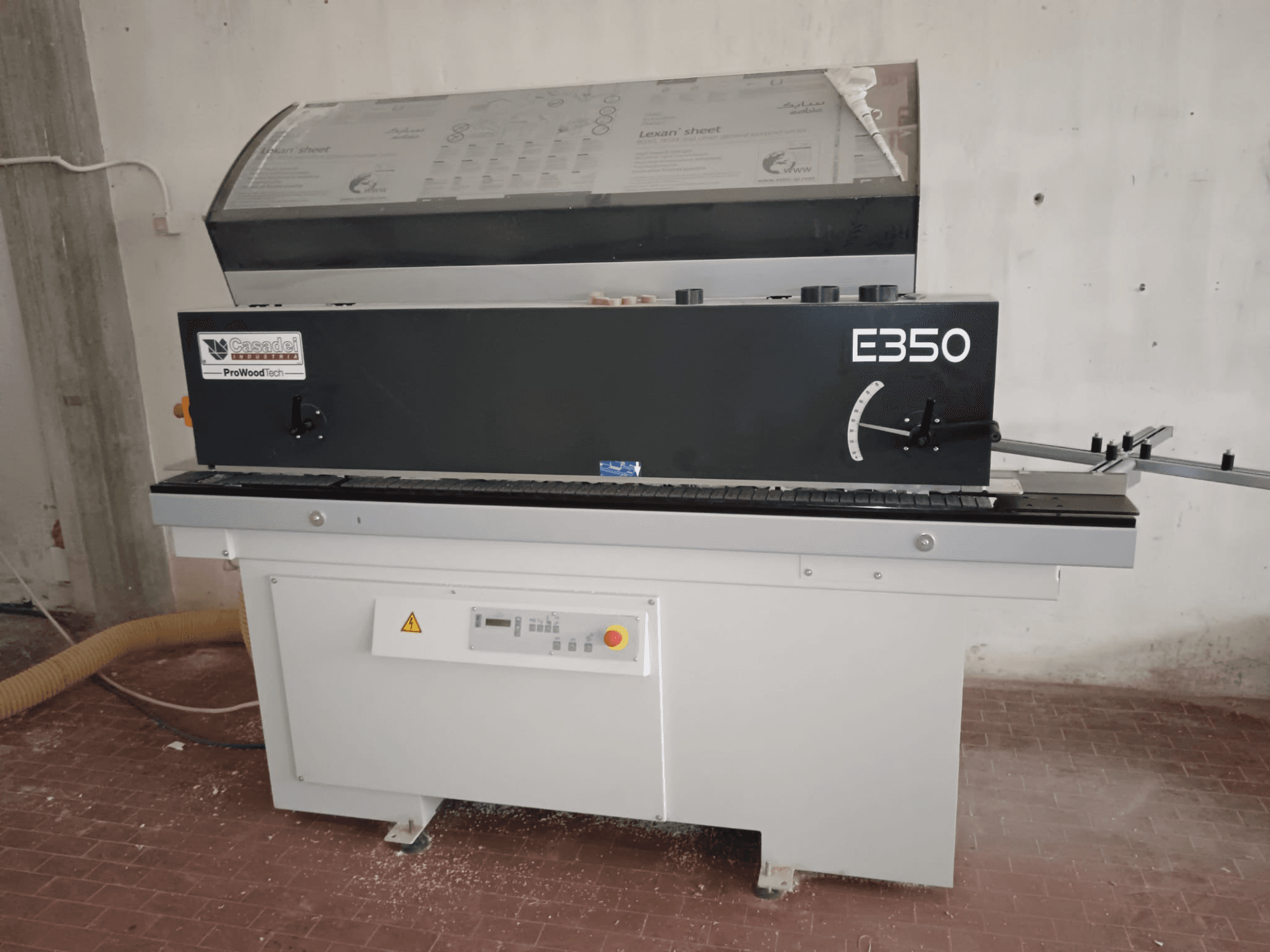 Cesaroli ProWoodtech E350, widok z boku maszyny do obróbki drewna z panelem sterowania i gromadzeniem pyłu, zamontowana na białej podstawie.