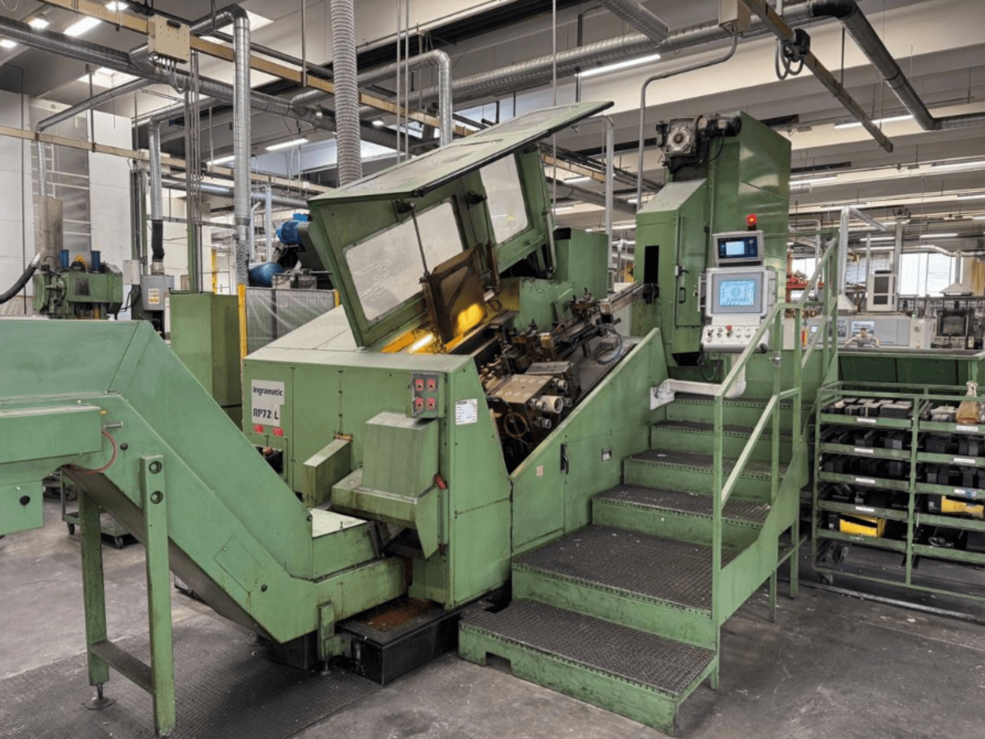 Ingramatic RP72 L, maszyna przemysłowa w kolorze zielonym, widok z przodu; posiada panel sterowania i stopnie z metalową platformą rusztową.
