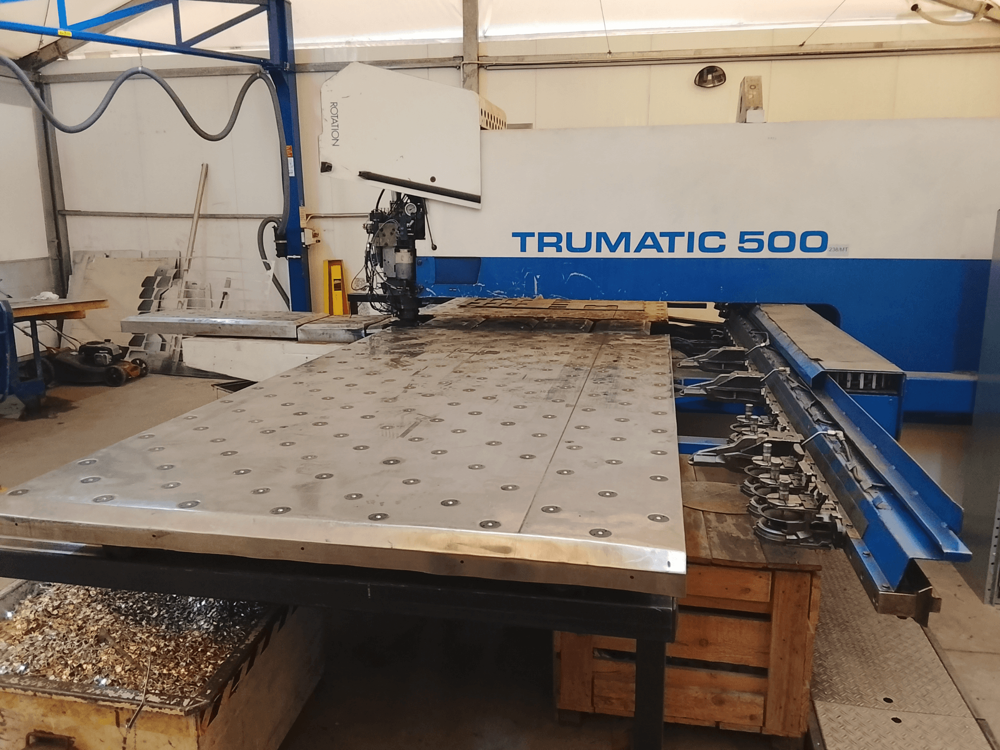 Maszyna CNC Trumatic 500, widok z góry, z dużym stołem do cięcia metalu z zamontowanymi narzędziami i wiórami pod spodem.