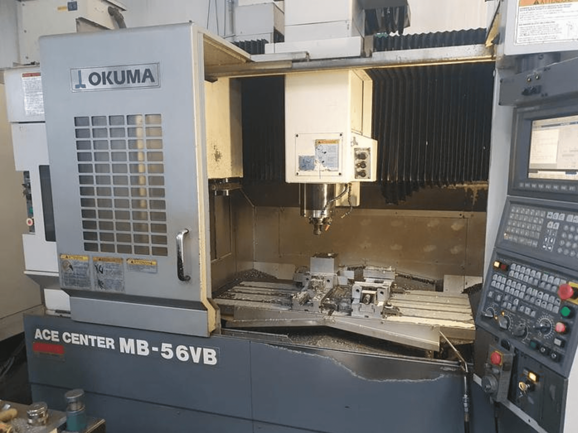 Frezarka CNC Okuma ACE CENTER MB-56VB w widoku z przodu, prezentująca panel sterowania i obszar obróbki.