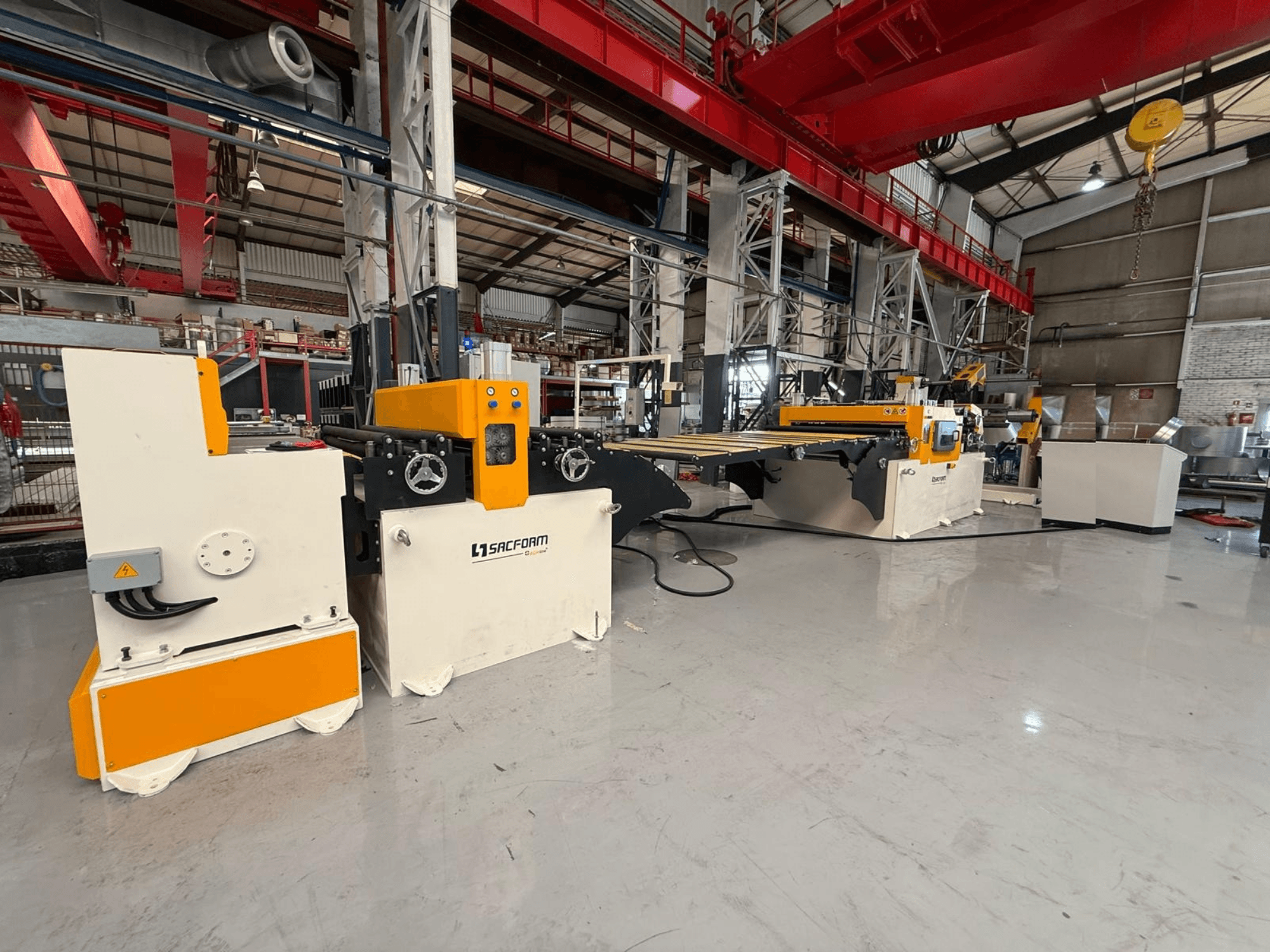 Widok z przodu maszyny do obróbki blachy SACFORM CRL1503-6, charakteryzującej się żółto-białą kolorystyką, kółkami oraz elementami sterującymi.