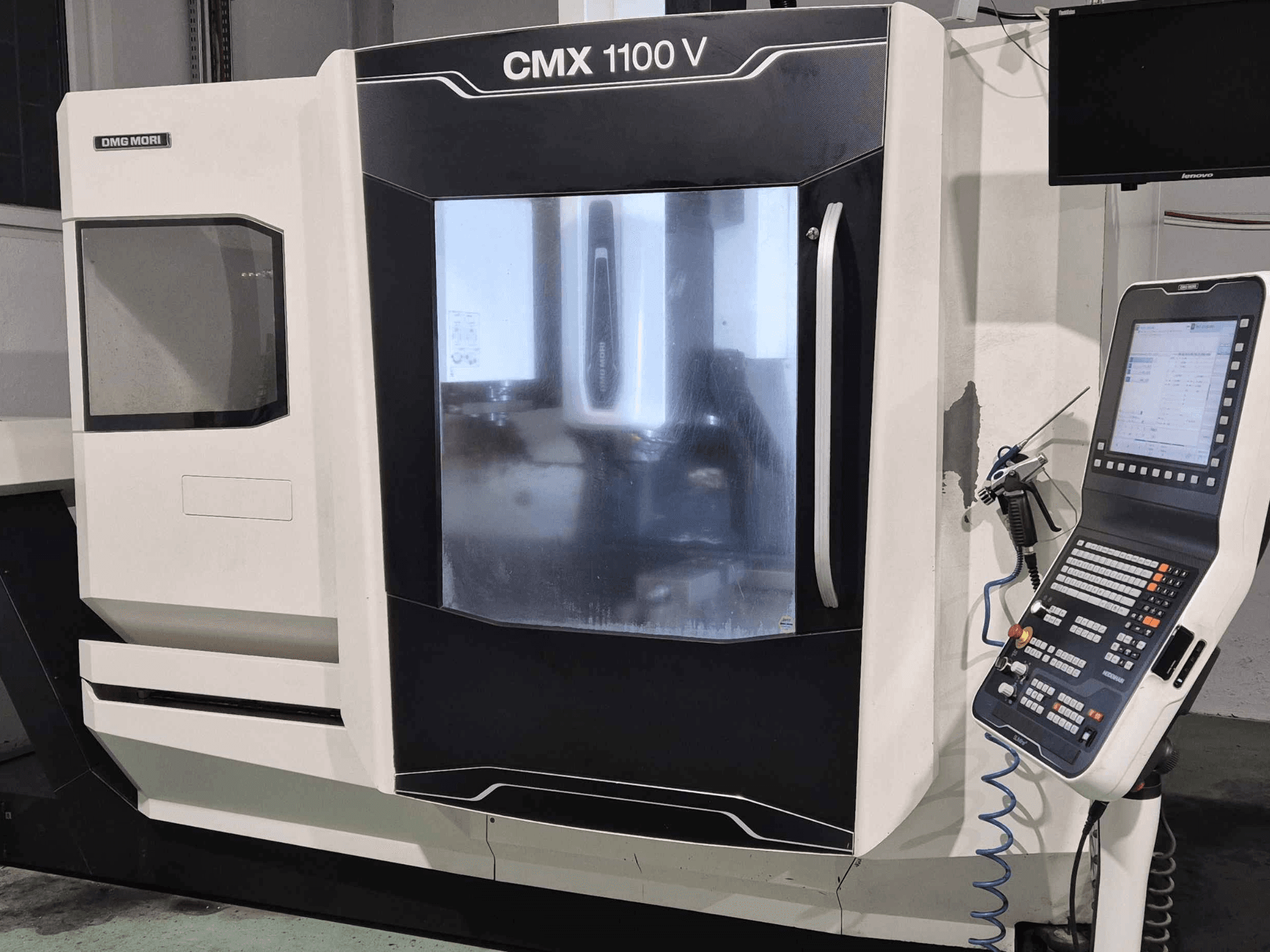 DMG Mori CMX 1100 V, widok z przodu maszyny CNC z widocznym panelem sterowania, wyświetlaczem cyfrowym i konfiguracją chłodziwa.