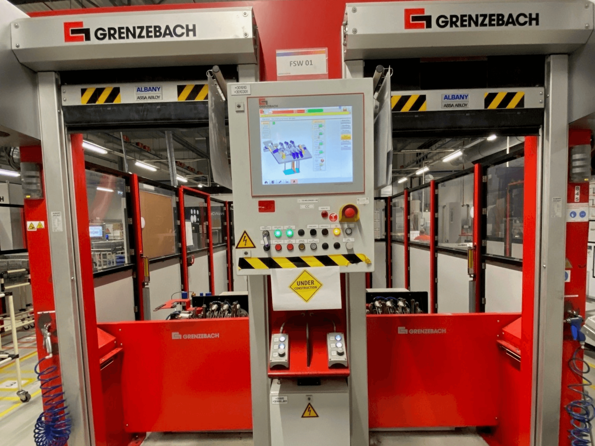 Widok z przodu ramienia robota GRENZEBACH FSW GenRob 01, wyposażonego w panel sterowania z ekranem dotykowym i różnymi przyciskami operacyjnymi.