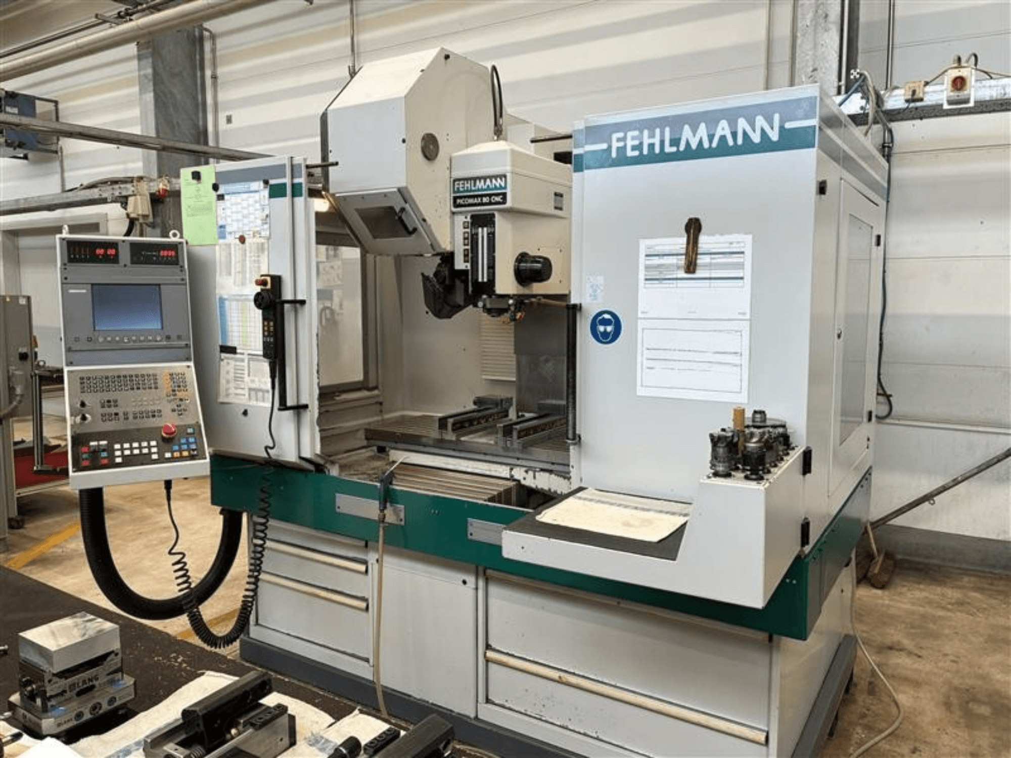 Pionowe centrum obróbcze FEHLMANN PICOMAX 80 CNC-W 2/3 widziane z przodu, z panelem sterowania i obszarem obróbki.