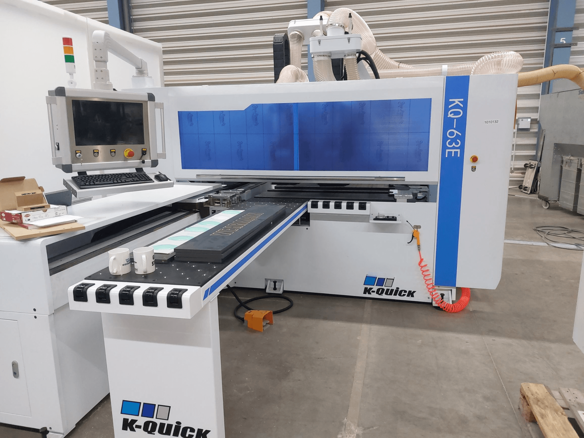 Maszyna CNC K-Quick KQ-63E widziana od przodu, z panelem sterowania, płaskim łożem i widocznym rozmieszczeniem narzędzi.