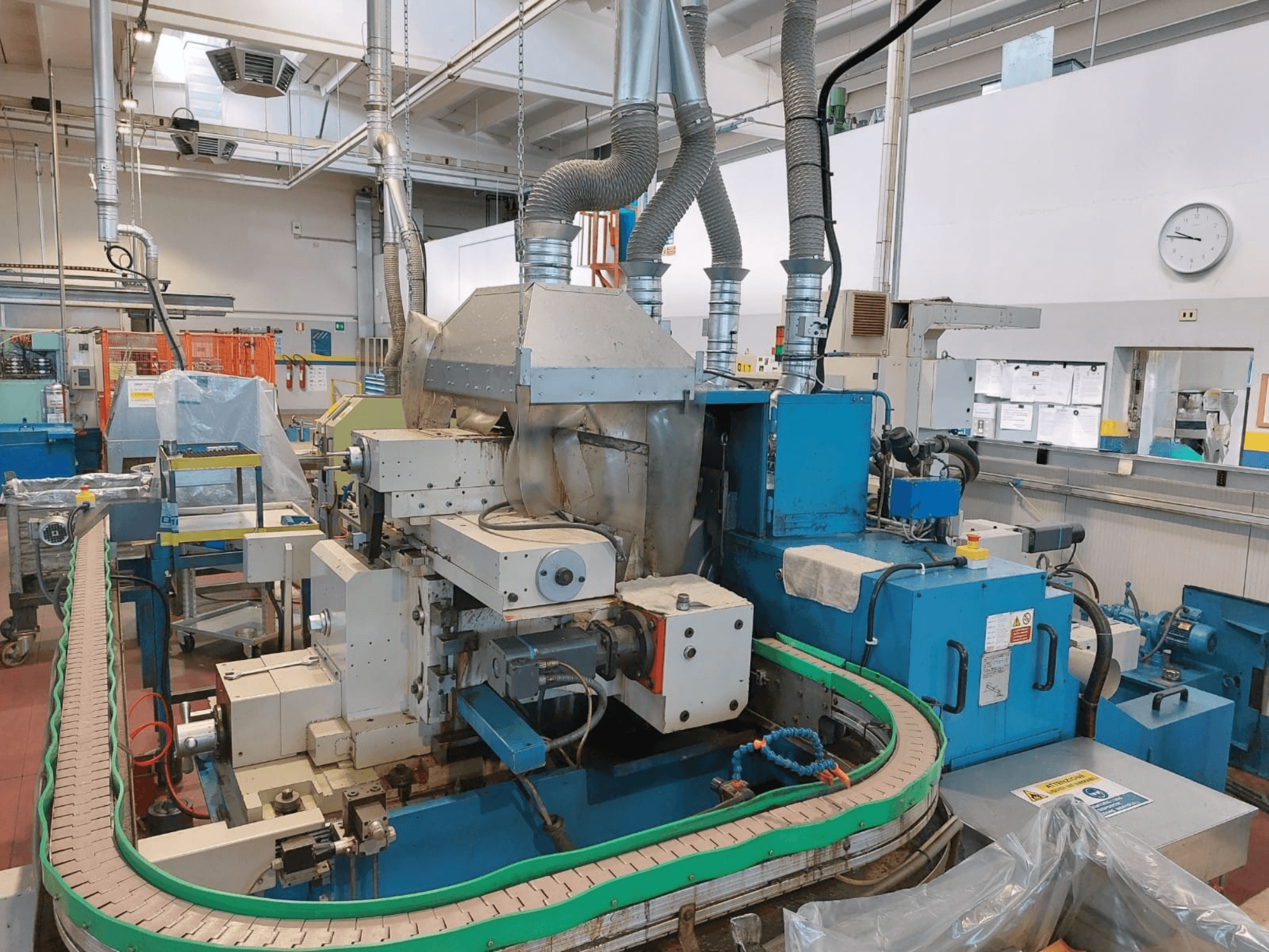 Szlifierka bezkłowa GHIRINGHELLI M300SP610 CNC3A, widok z przodu, prezentująca skomplikowane maszyny i szczegóły przenośnika.