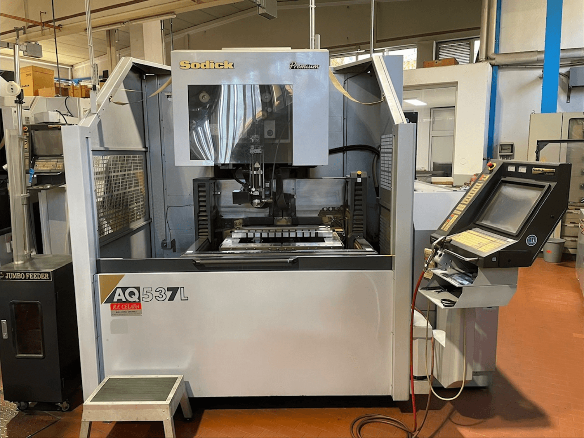 Elektrodrążarka drutowa Sodick AQ537L w widoku z przodu, z panelem sterowania i obszarem obróbki z widocznymi komponentami.