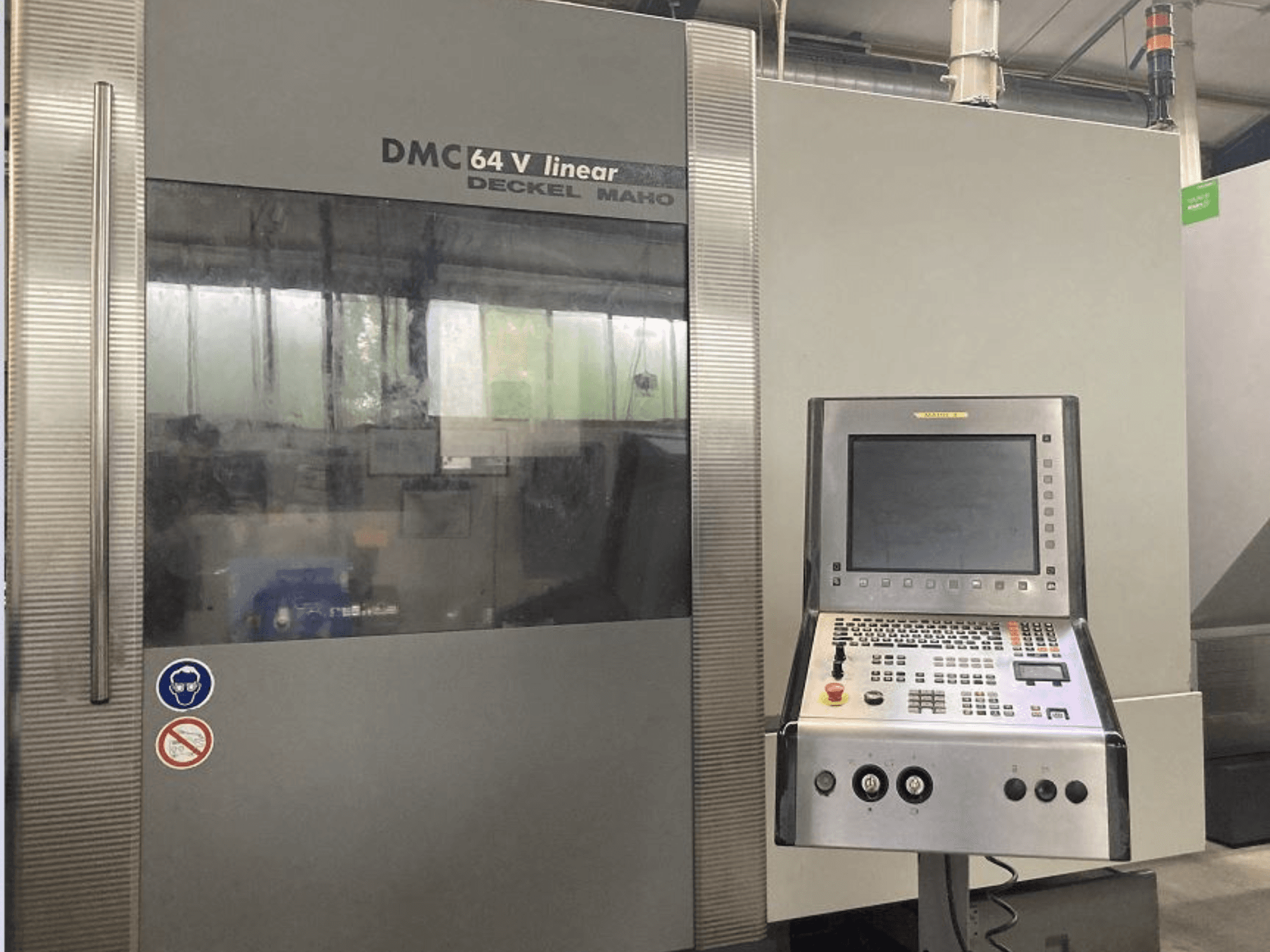 Liniowe pionowe centrum obróbkowe DMG DECKEL MAHO DMC 64V, widok z przodu przedstawiający panel sterowania i wyświetlacz.