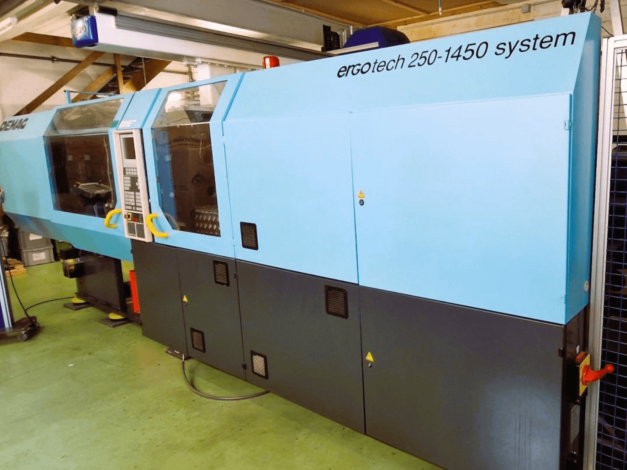 Wtryskarka systemowa Ergotech 250-1450, widok z przodu, kolor niebiesko-czarny, widoczny panel sterowania i zabezpieczenia.