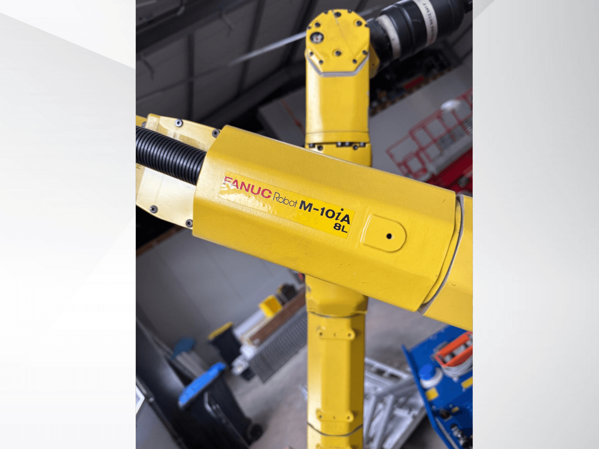 Robot FANUC M-10iA 8L w kolorze żółtym, widziany z boku, prezentujący przegub ramienia i komponenty mechaniczne w środowisku przemysłowym.