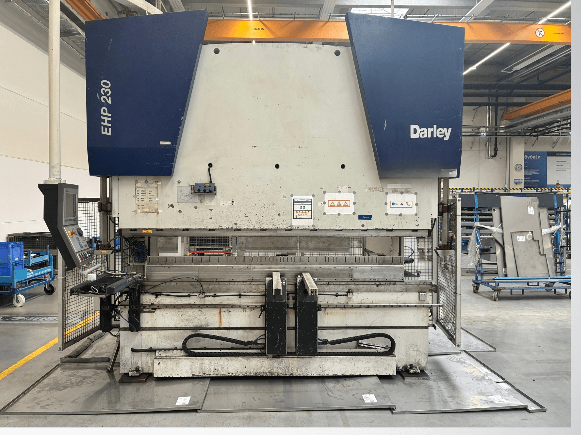 Prasa hydrauliczna Darley EHP-LS 230.31/25, widok z przodu, z panelem sterowania i blachami w pobliżu. Idealna do zastosowań przemysłowych.