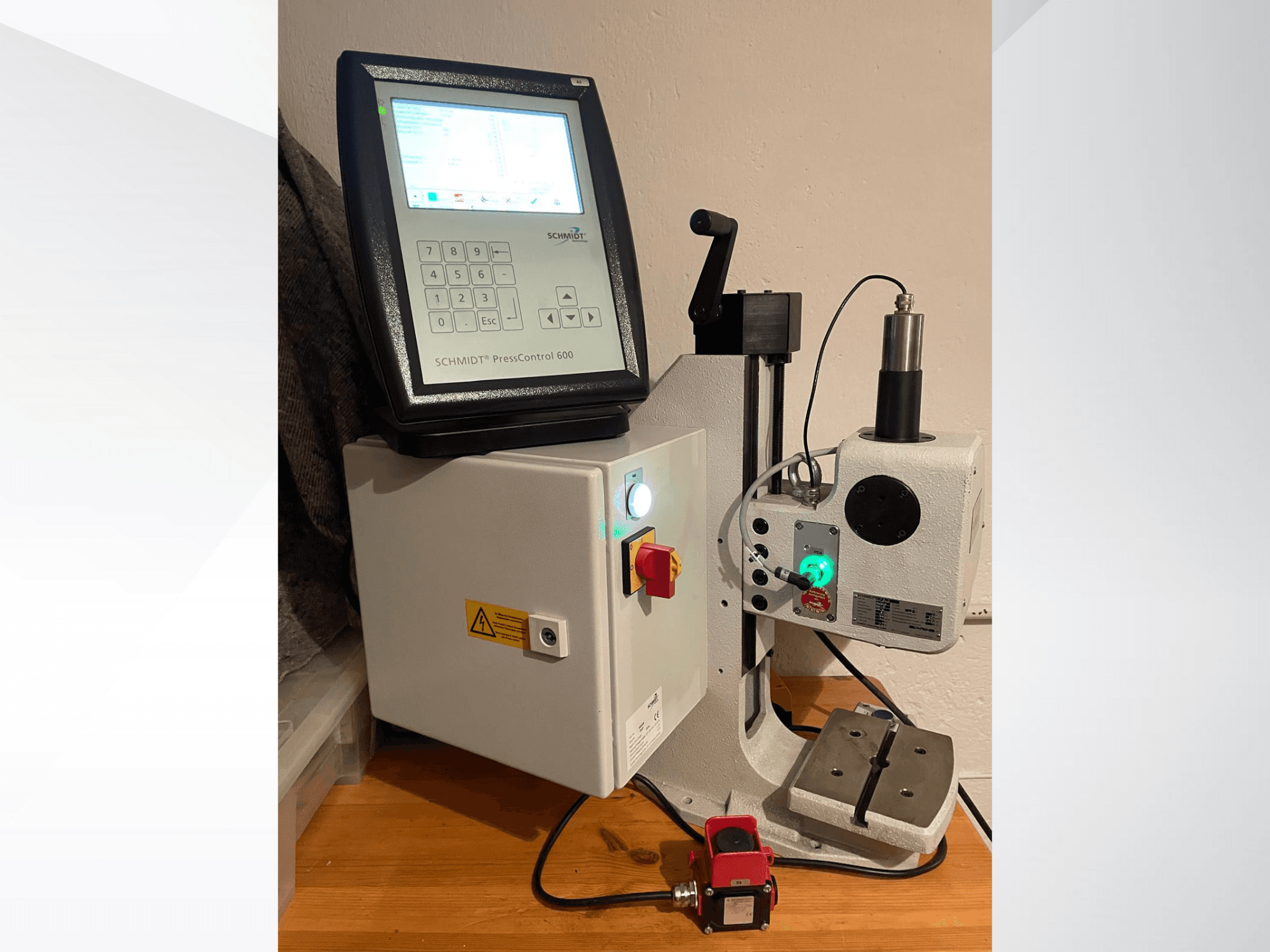 SCHMIDT® PressControl 600, widok z przodu, pokazujący panel sterowania, przycisk zasilania i prasę hydrauliczną z funkcjami bezpieczeństwa.