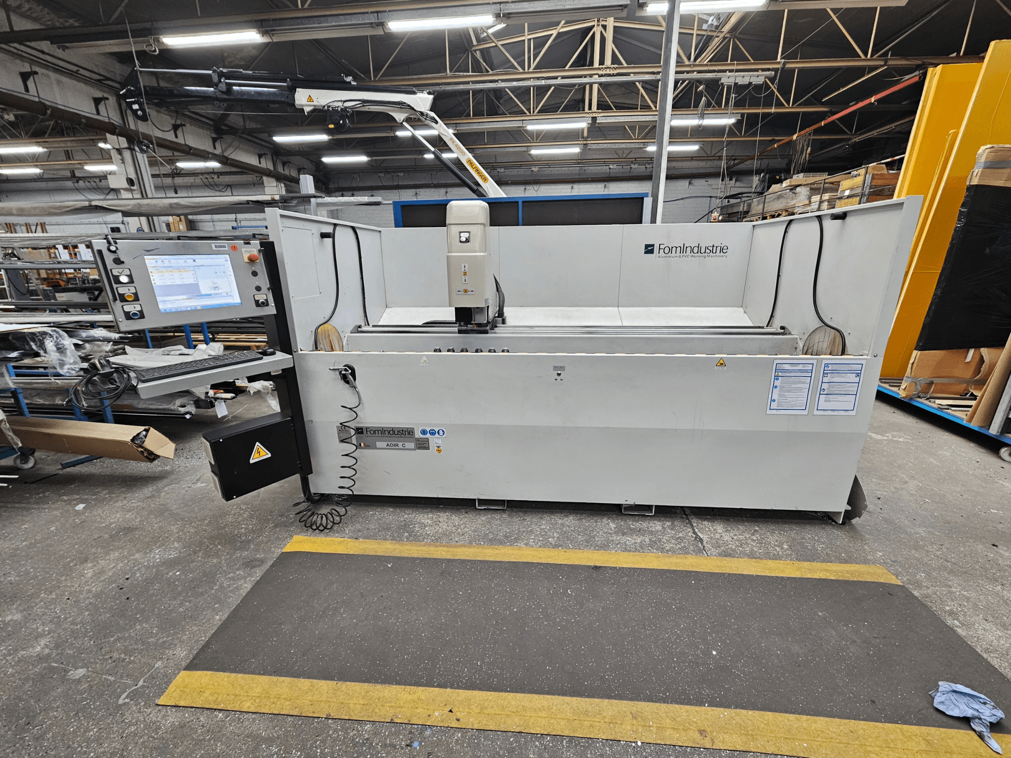 Pionowe centrum obróbcze FomIndustrie ADIR C w warsztacie, widok z przodu przedstawiający panel sterowania i szczegóły maszyny.