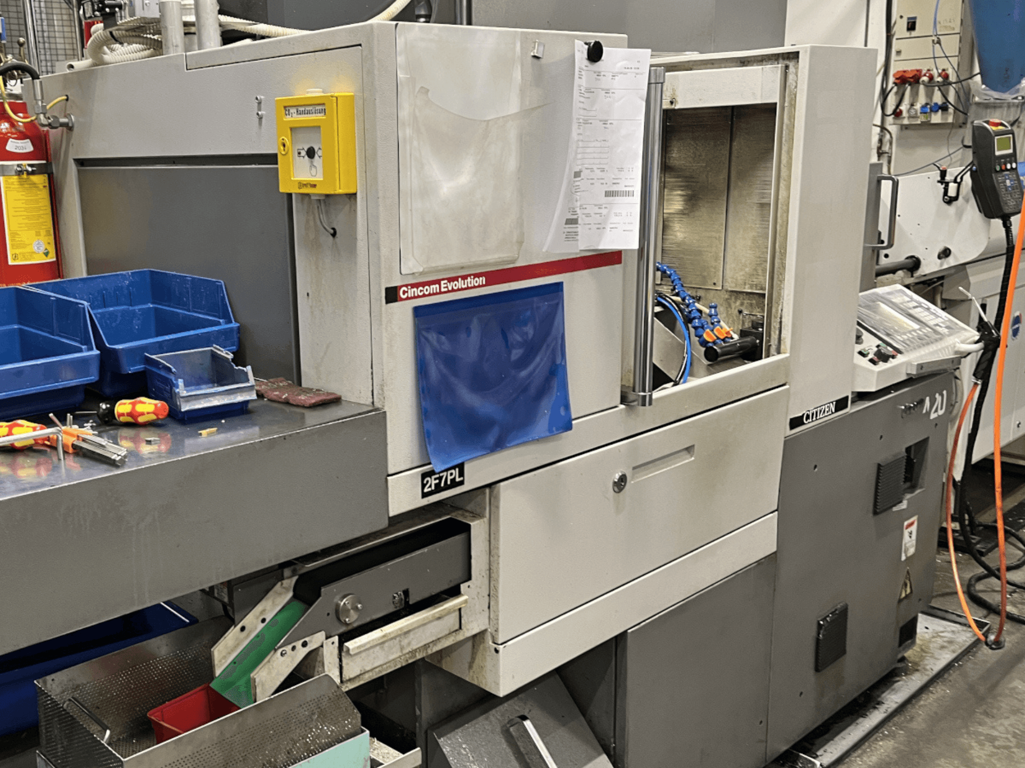 Centrum obróbcze Cincom Evolution 2F7PL, widok z przodu; zawiera elementy sterujące, pojemniki na narzędzia i szczegółowy panel operacyjny.