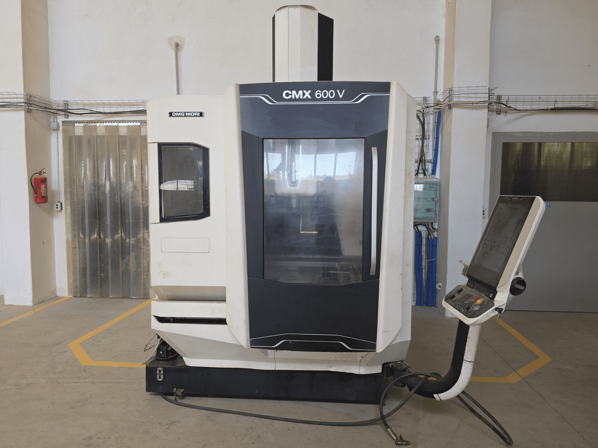 Pionowe centrum obróbcze DMG MORI CMX 600 V, widok z przodu, panel sterowania i duże przezroczyste okno.