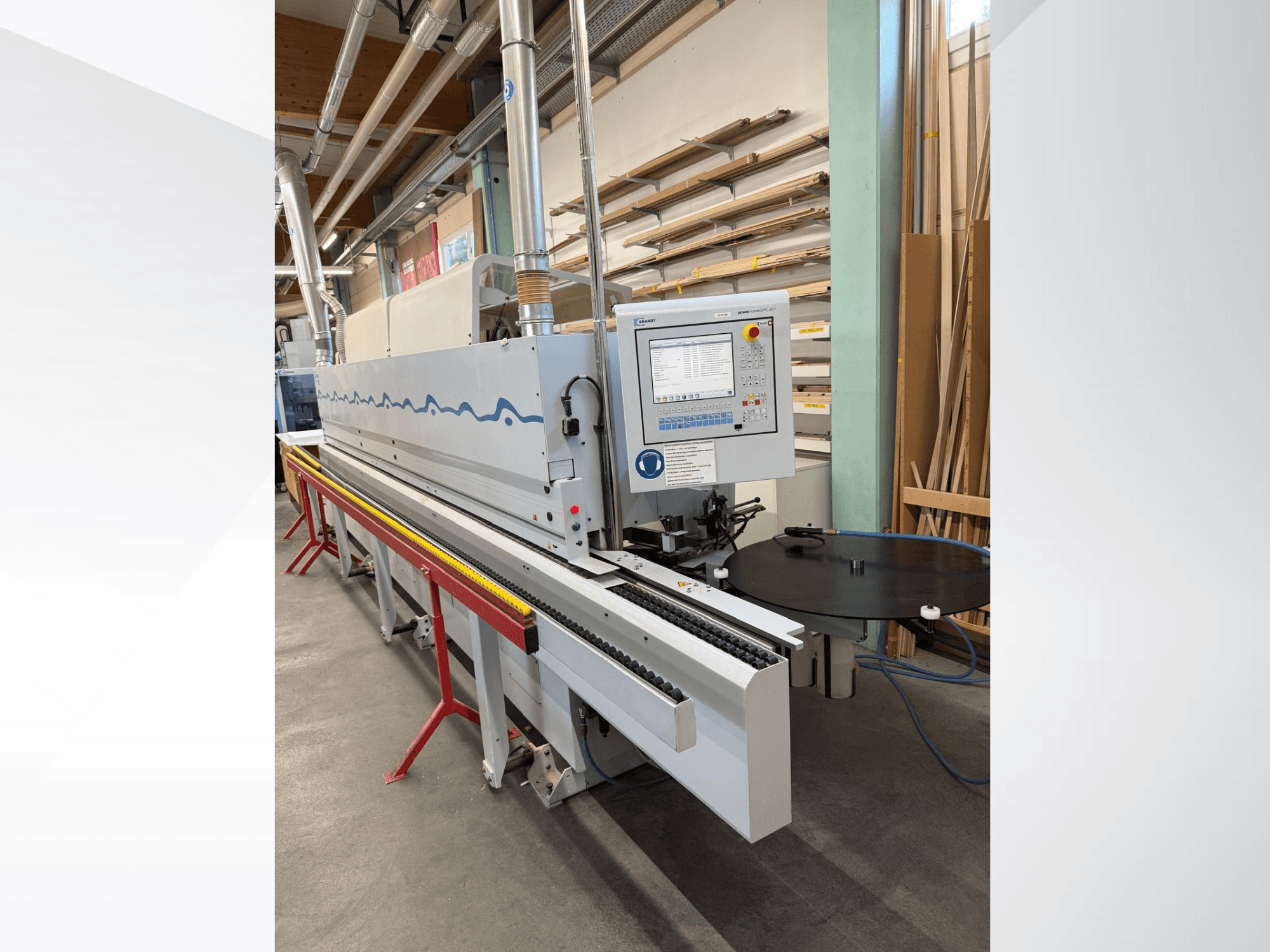 Widok z przodu automatycznej okleiniarki HolzHer z panelem sterowania, systemem transportowym i okrągłym stołem podporowym.