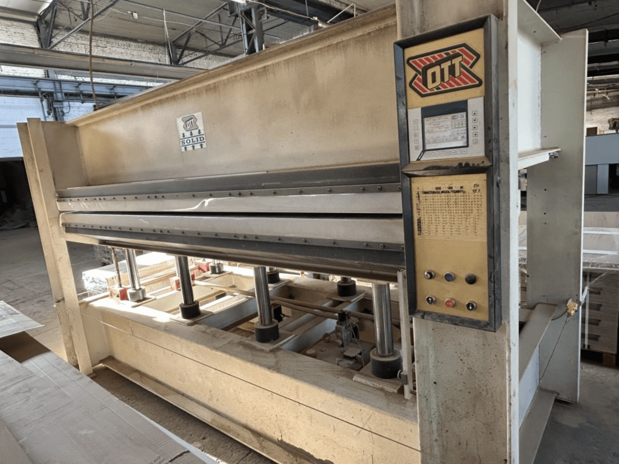 Widok z przodu prasy do laminowania OTT SOLID 16-32, przedstawiający panel sterowania i elementy hydrauliczne.