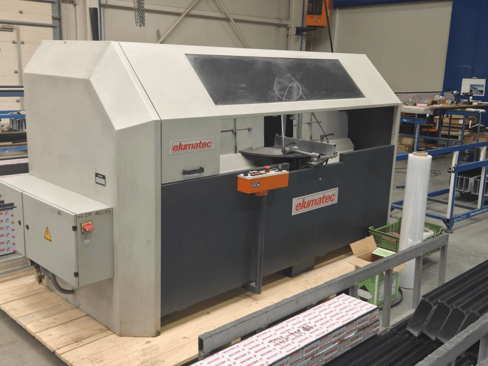 Pilarka tarczowa do metalu Elumatec AKS 134, widok z przodu, panel sterowania i obszar cięcia na drewnianej platformie.