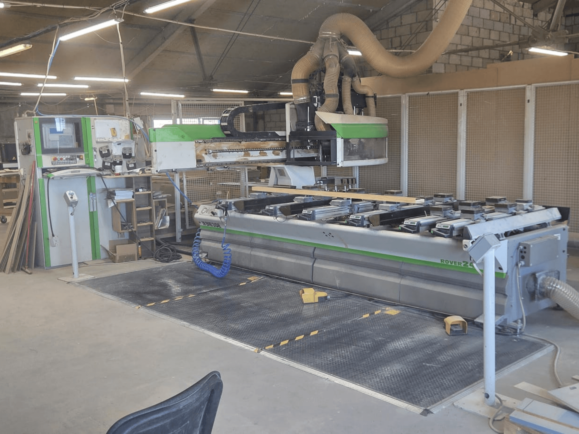 Centrum obróbcze CNC BIESSE Rover 24S w warsztacie, wyposażone w panel sterowania i dużą powierzchnię roboczą z elementami drewnianymi.