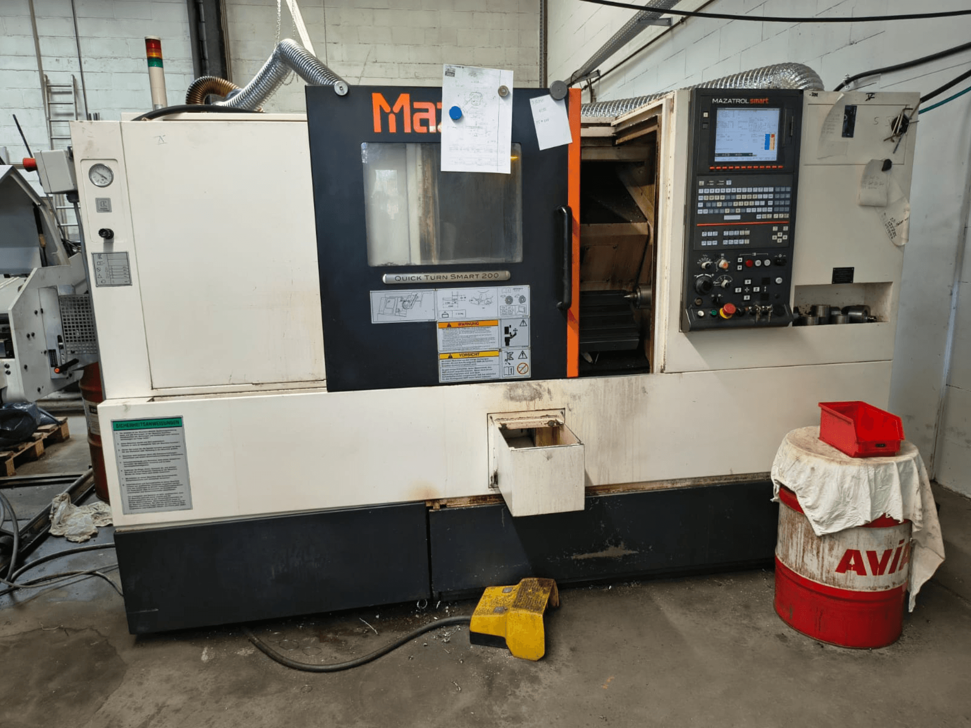 Mazak Quick Turn Smart 200, pozioma tokarka, widok z przodu z widocznym panelem sterowania, zbiornikiem chłodziwa i oznaczeniami.