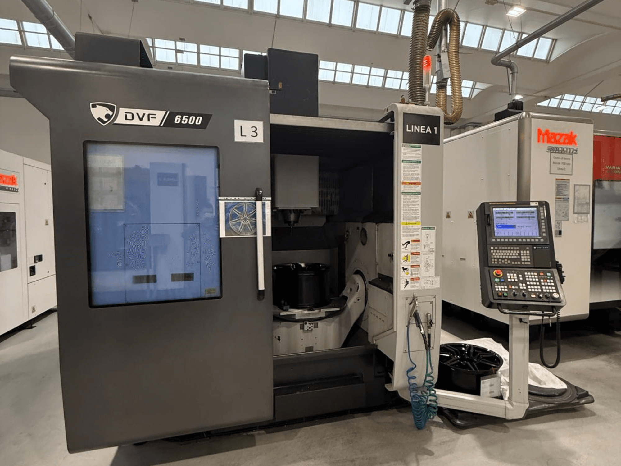 Maszyna CNC DVF 6500, widok z przodu, pokazujący panel sterowania i przestrzeń wewnętrzną z mocowaniem części.