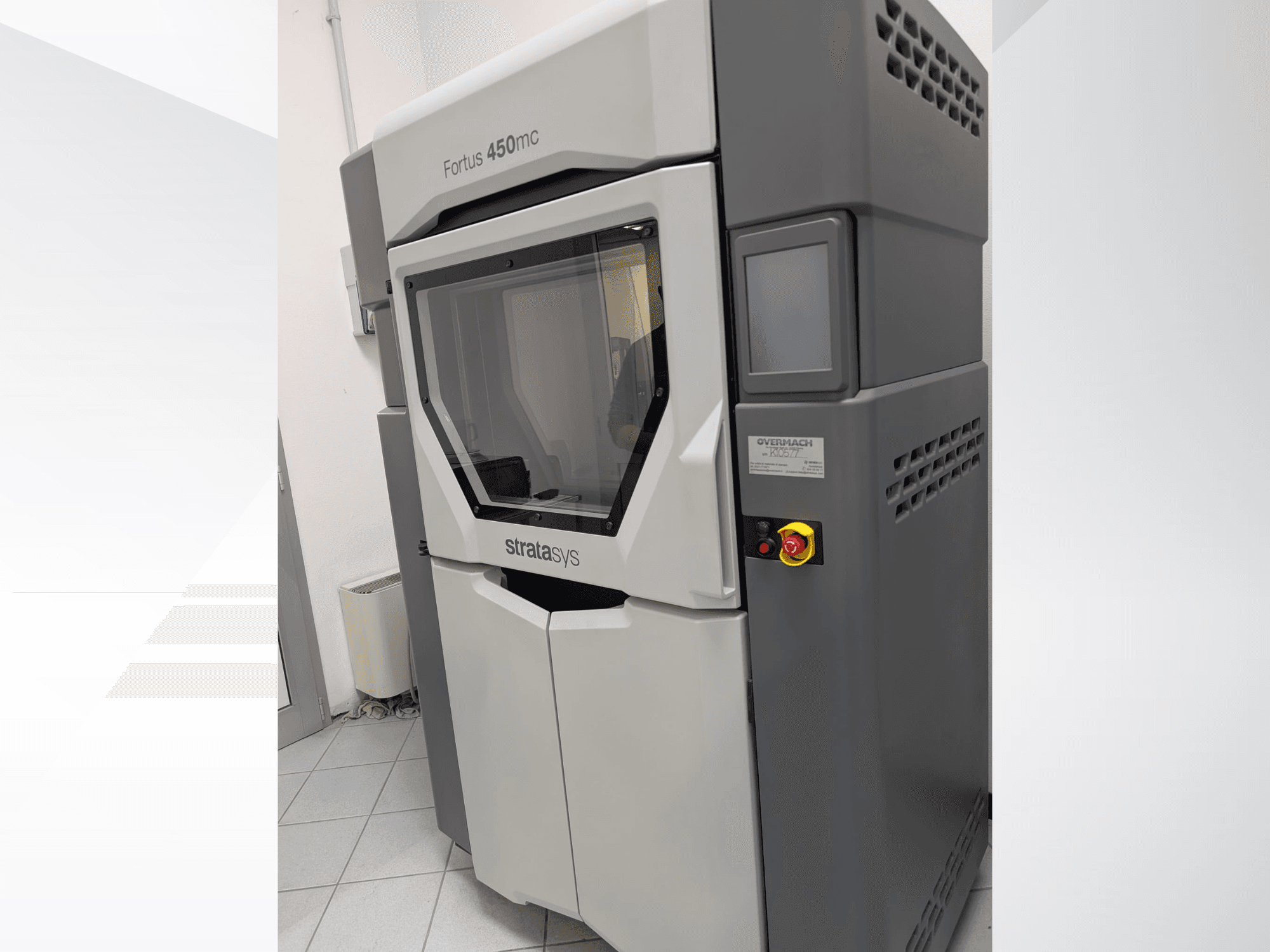 Plastikowa drukarka 3D Fortus 450mc w widoku z boku, z przezroczystym panelem przednim i przyciskami sterującymi z boku.