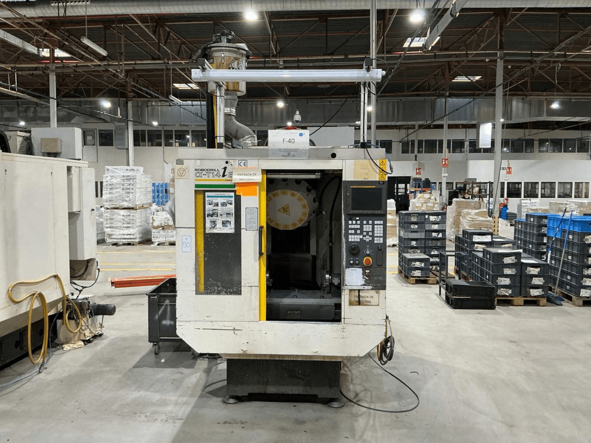 Pionowe centrum obróbcze FANUC ROBODRILL α-T14iB w fabryce, widok z przodu przedstawiający panel sterowania i uchwyt narzędziowy.