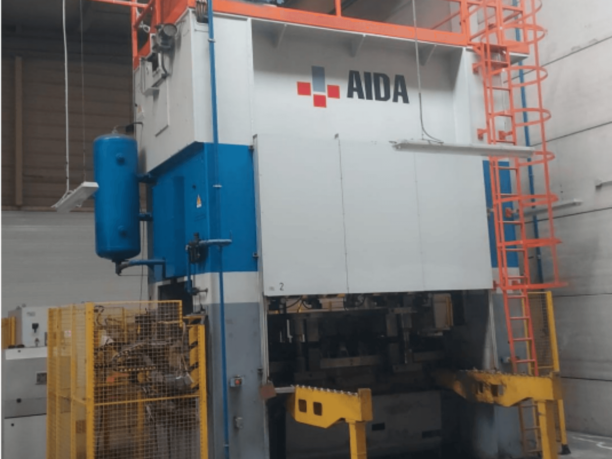 Mechaniczna prasa tłocząca AIDA 315/2MR/LD/TE 3, widok z przodu z niebiesko-białym korpusem, żółtą podstawą i klatką bezpieczeństwa.