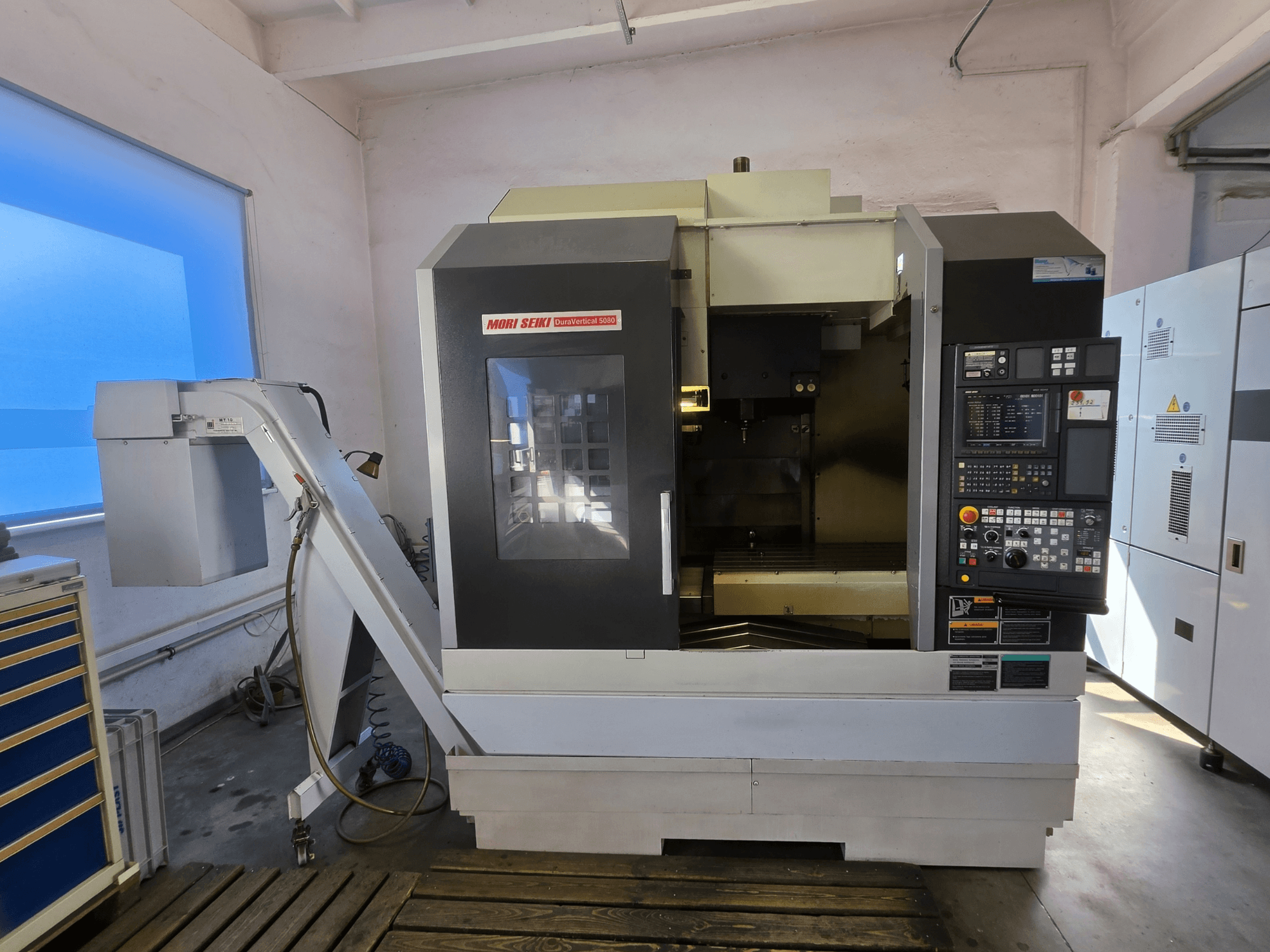 Pionowe centrum obróbcze MORI SEIKI DuraVertical 5080 – widok z przodu przedstawiający panel sterowania, wrzeciono i uchwyt narzędziowy.