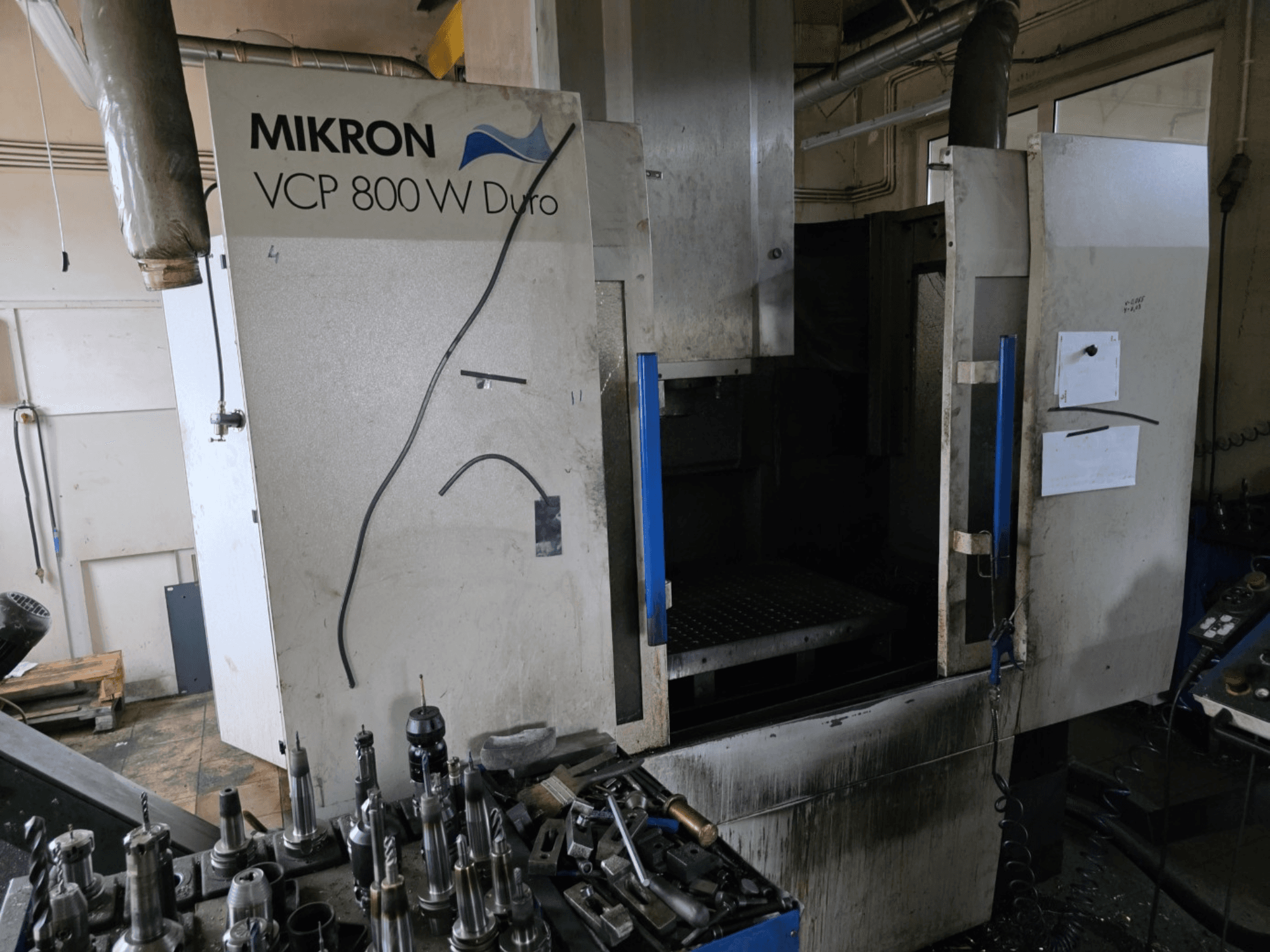 Frezarka Mikron VCP 800 W Duro pokazana z boku, z narzędziami i elementami sterującymi widocznymi na pierwszym planie.