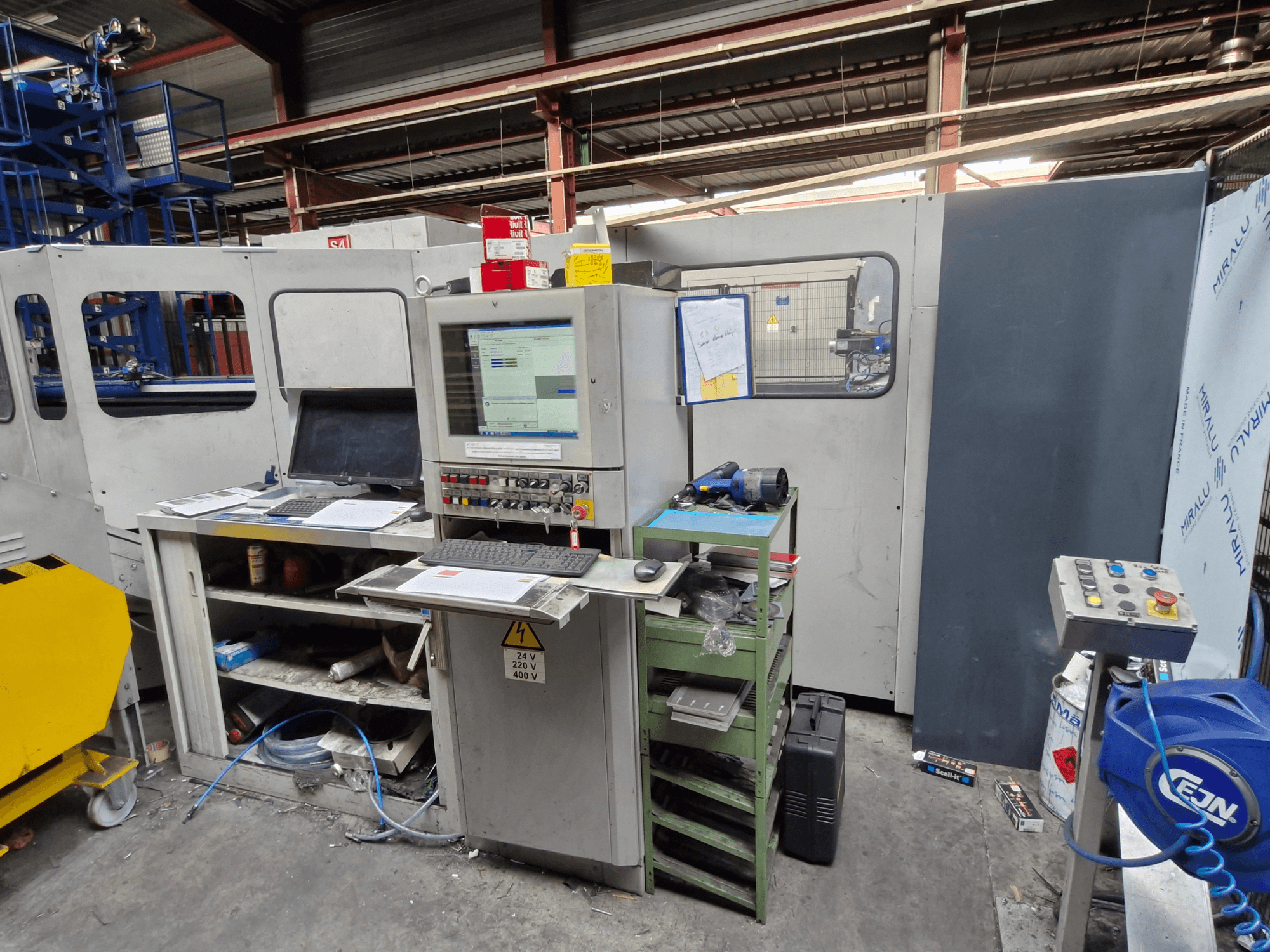 Wykrawarka CNC Salvagnini S4-40 w warsztacie, z panelem sterowania z monitorami i narzędziami, widok z przodu.