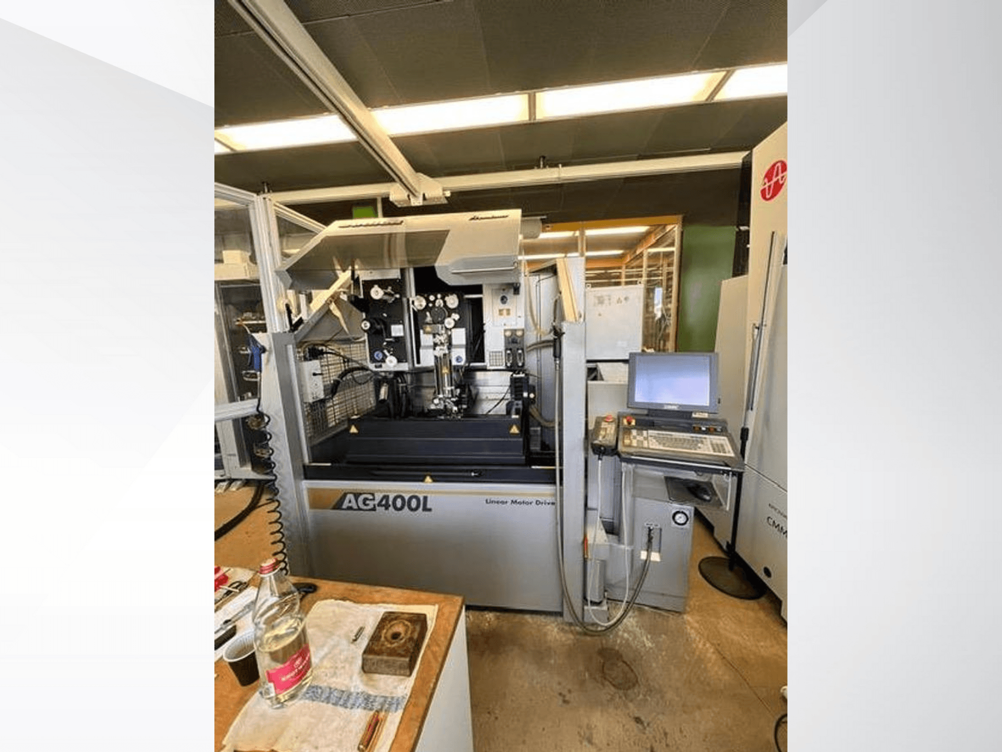 Maszyna z napędem liniowym AG400L, widok z przodu, z panelem sterowania i obszarem roboczym z widocznymi funkcjami bezpieczeństwa.