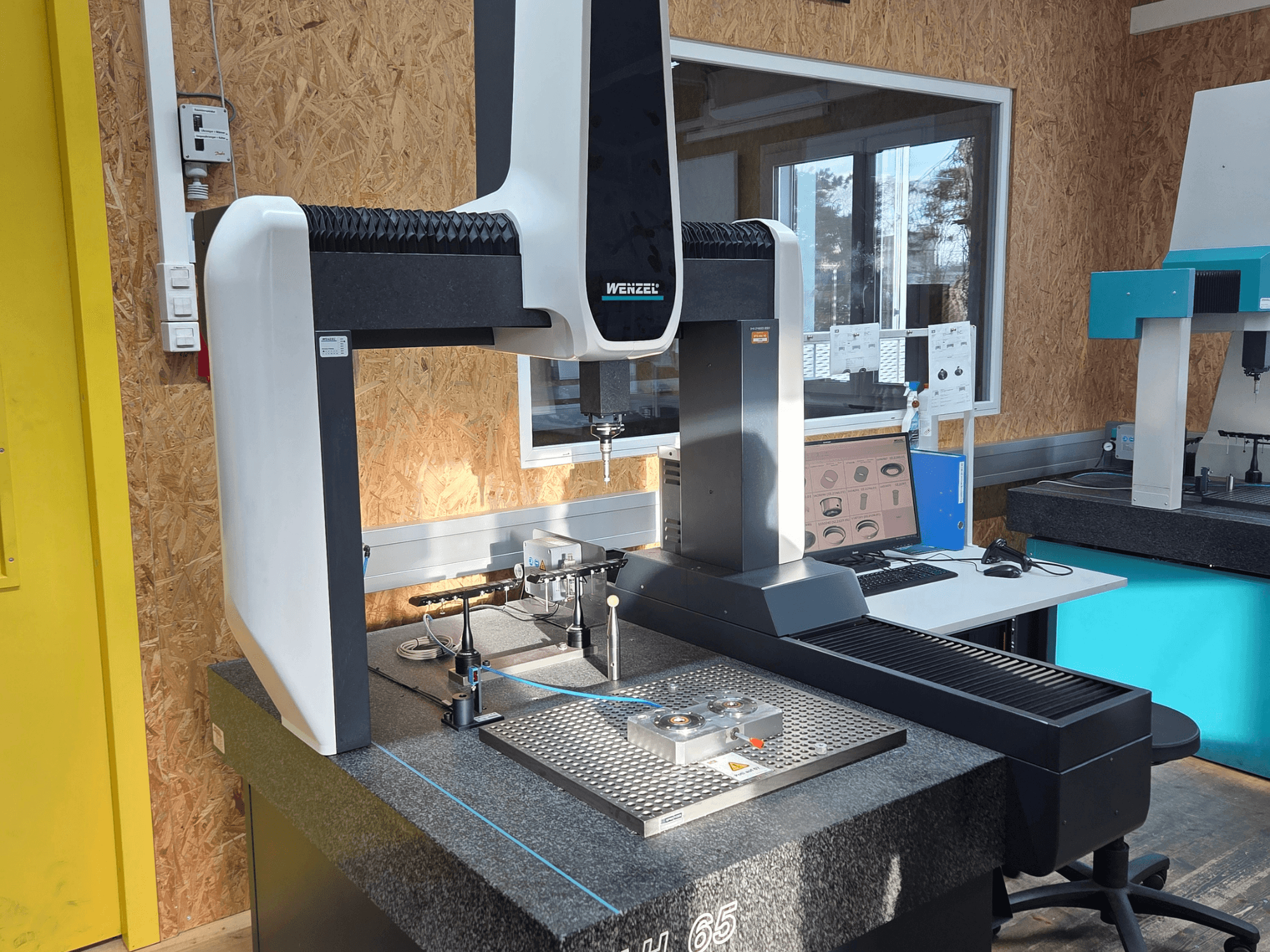 Współrzędnościowa maszyna pomiarowa Wenzel LH 65 w konfiguracji laboratoryjnej, widok z przodu, wyświetlanie narzędzi pomiarowych i monitora.