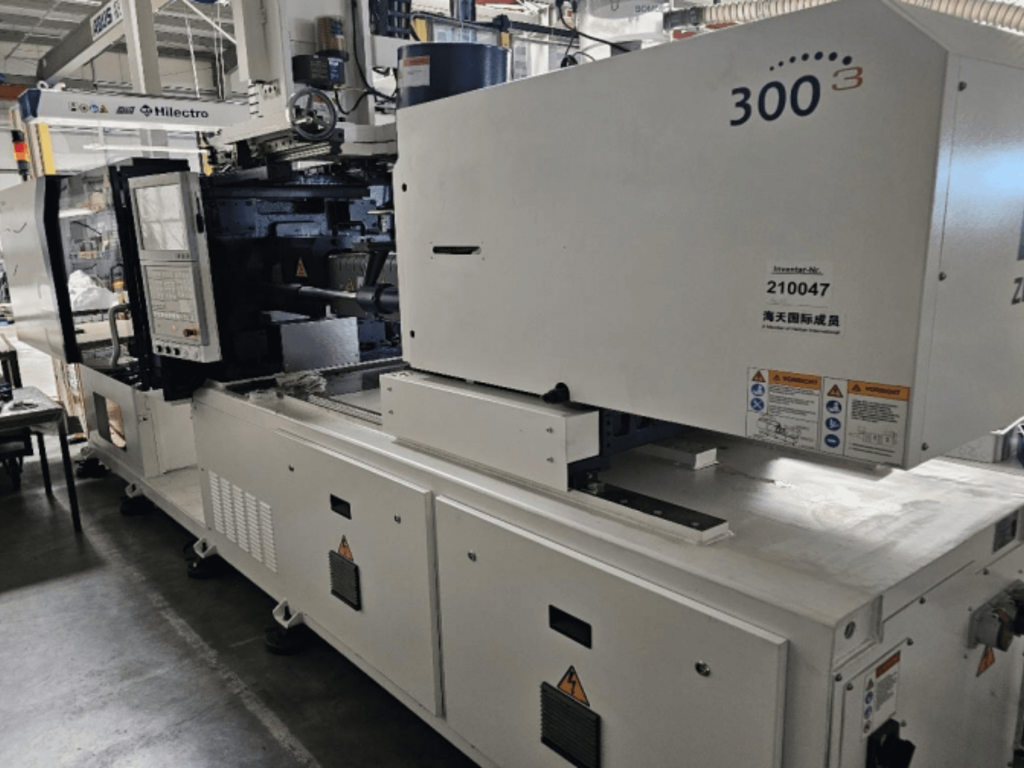 Wtryskarka, marka Zhenjing, model 300, widok z przodu z widocznym panelem sterowania i etykietami ostrzegawczymi.