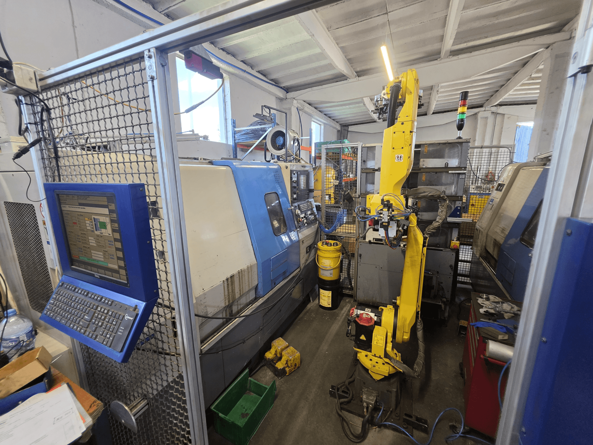 Pozioma tokarka Hyundai HIT-200C z robotem FANUC M-20iA – widok z przodu przedstawiający interfejs sterowania i konfigurację maszyny.
