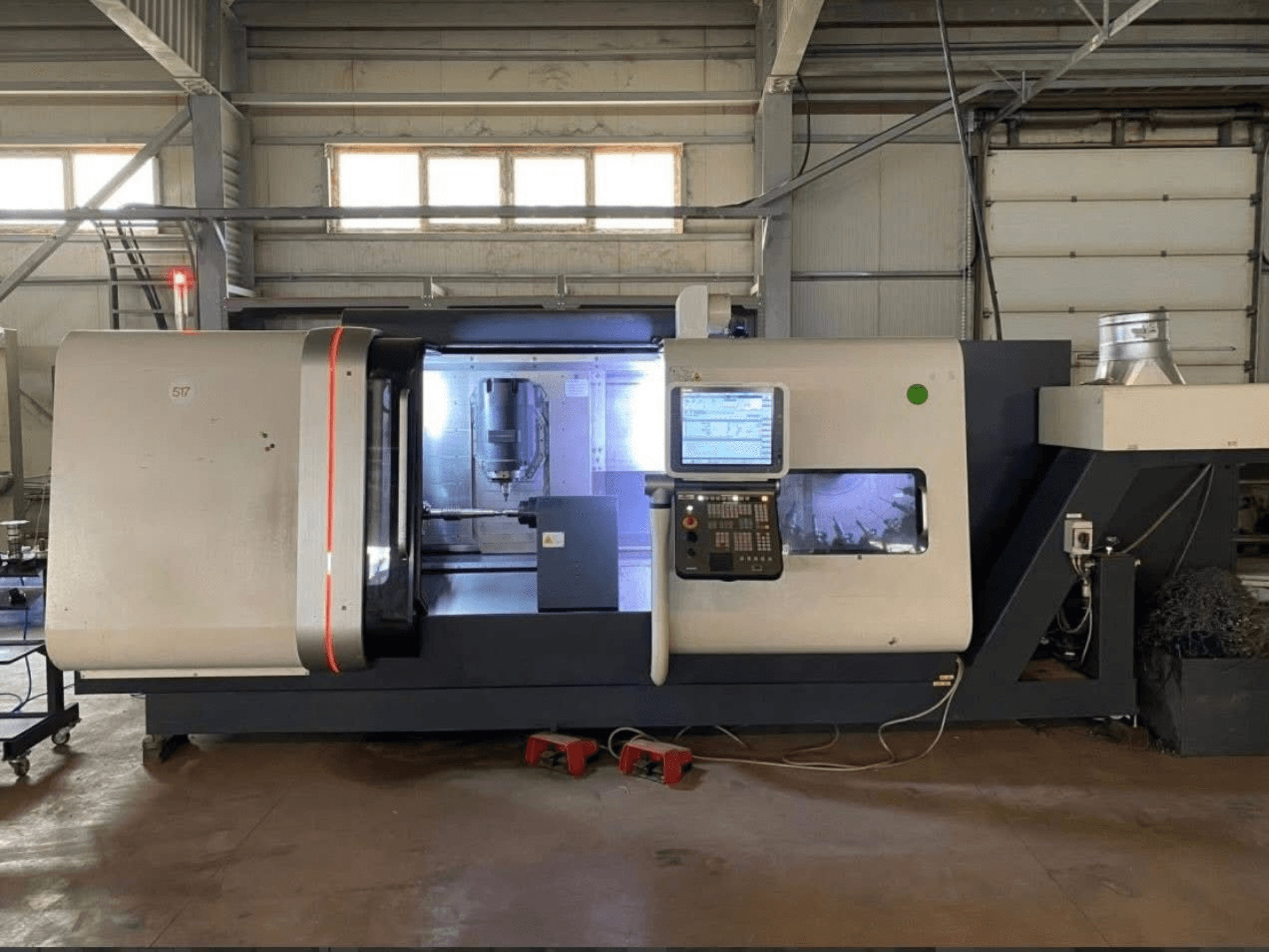 Centrum frezarskie DMG MORI Beta 1250 TC, widok z przodu z panelem sterowania, oświetlonym obszarem roboczym i widocznymi narzędziami tnącymi.