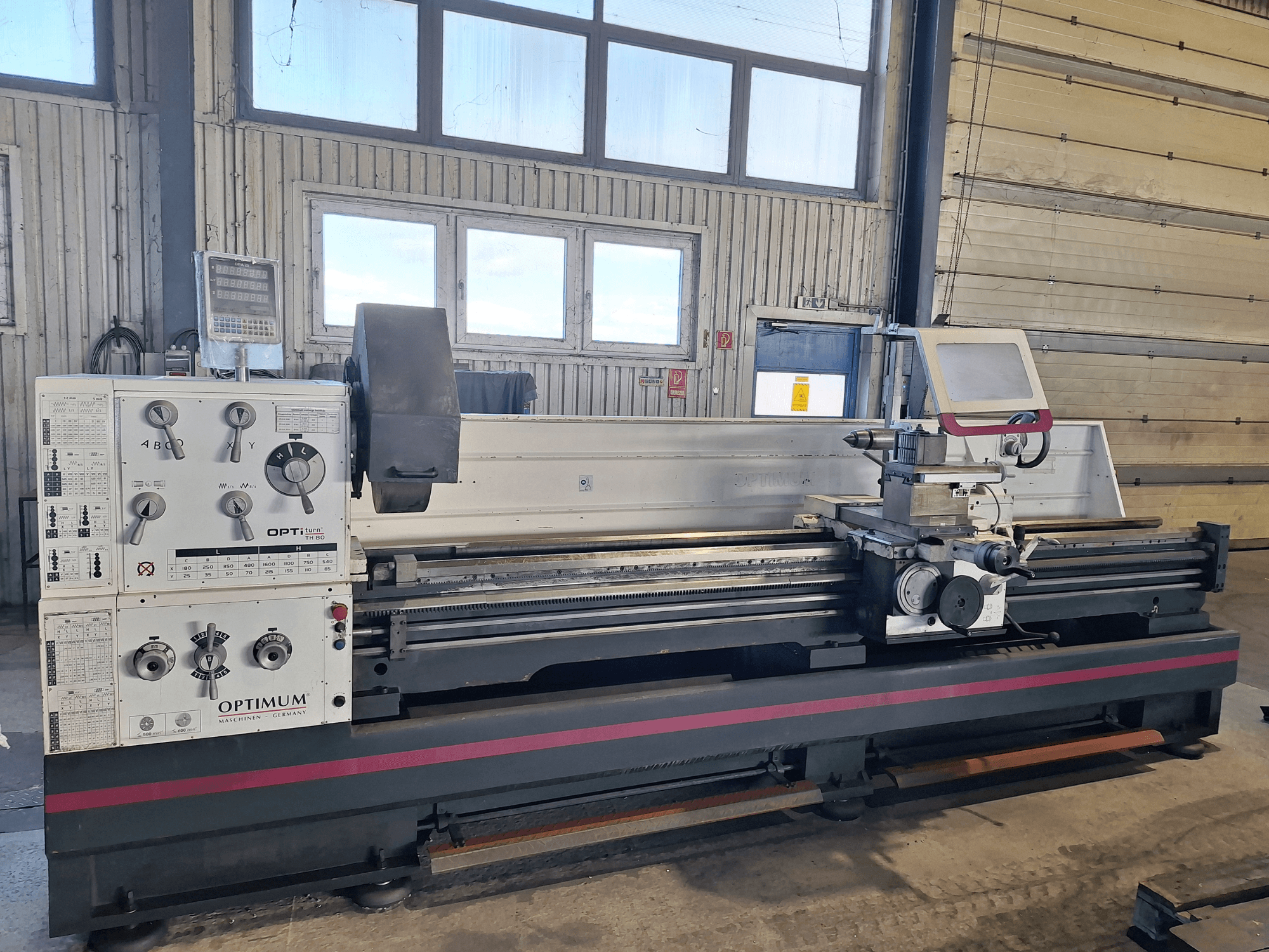 Tokarka pozioma Optimum OptiTurn TH 8030D w widoku z boku, z panelem sterowania, uchwytem narzędziowym i solidną podstawą.