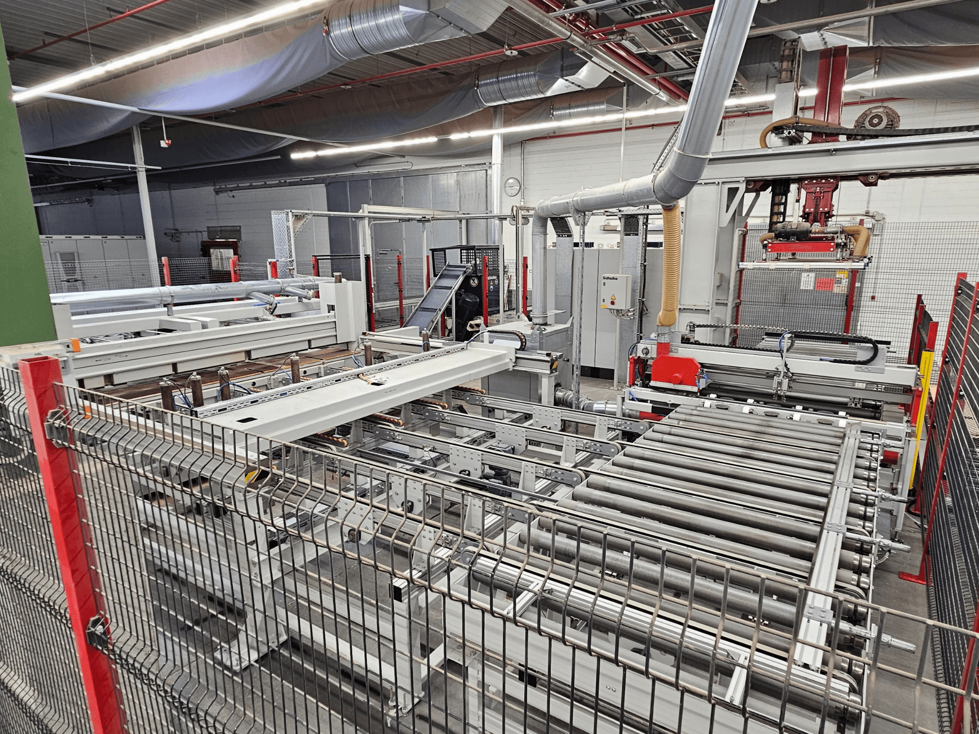 Pilarka panelowa HOLZMA HPP81-3200 pokazana w widoku z przodu, z rolkami przenośnika i komponentami maszyny w warunkach warsztatowych.