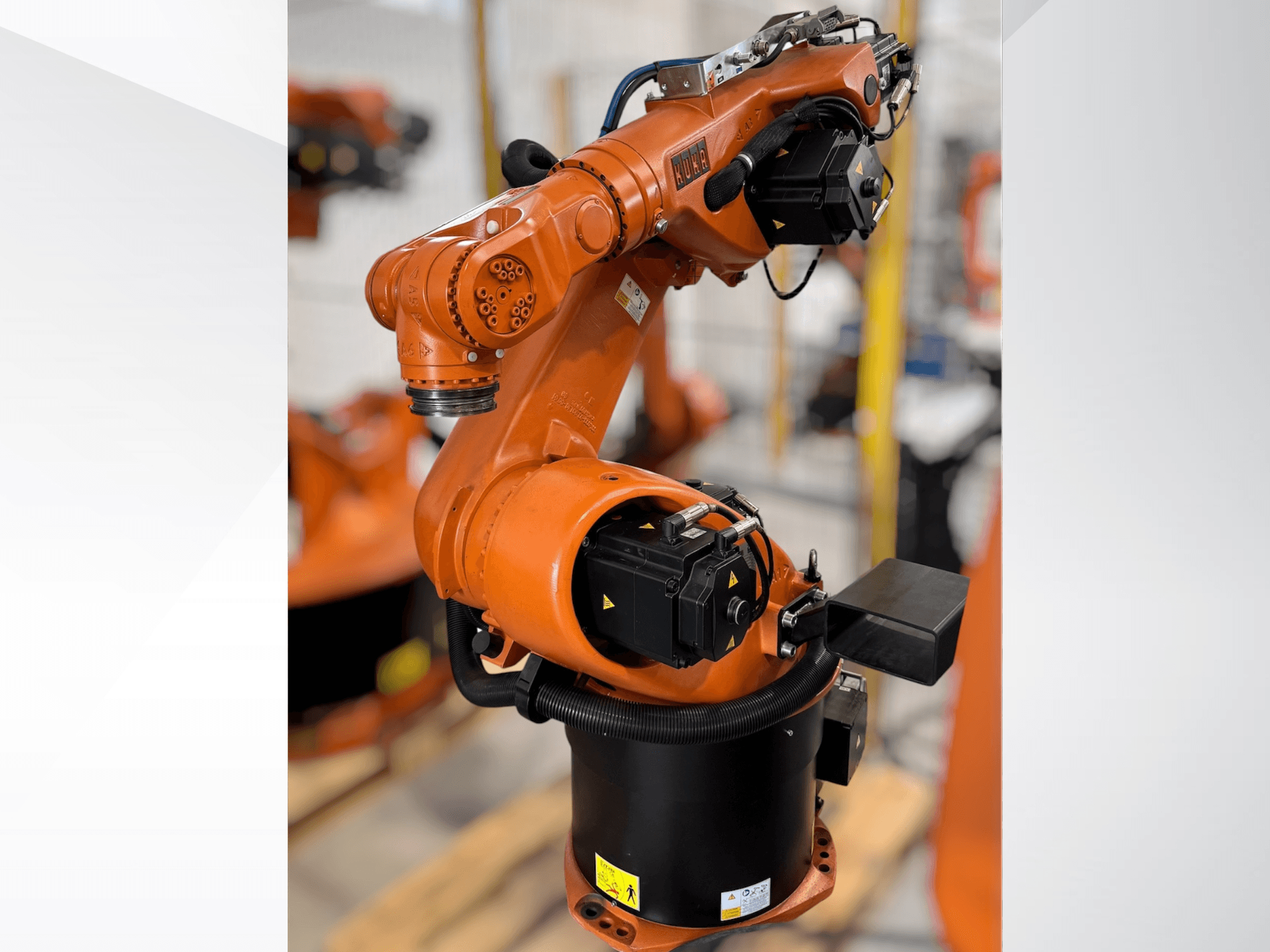 Ramię robota KUKA KR 60-3 w kolorze pomarańczowym; widok z boku pokazujący podstawę, przeguby i moduły sterowania do zadań automatyzacji.