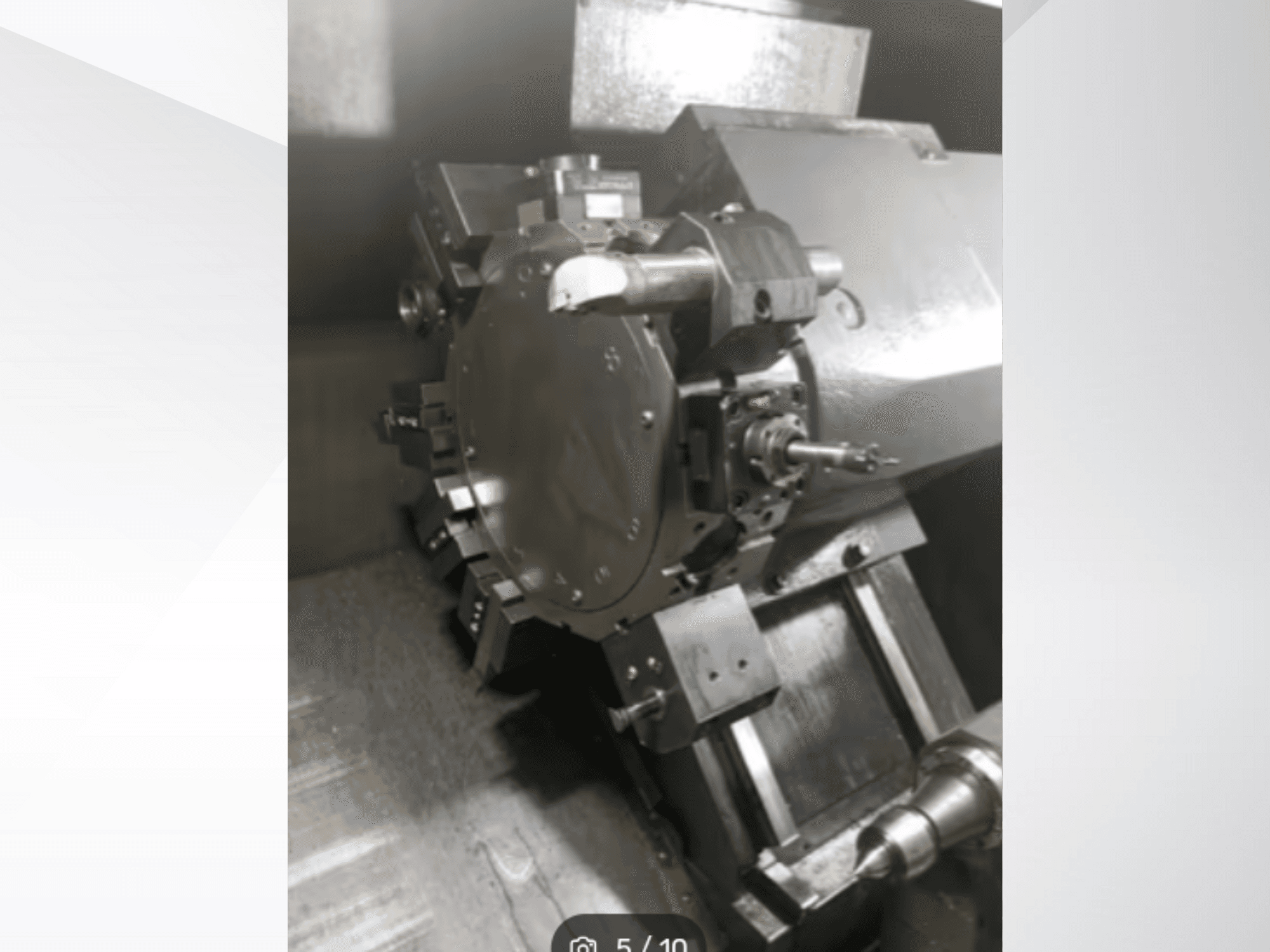 Zbliżenie precyzyjnej części maszyny, pokazujące koła zębate i metalowe elementy, widziane pod kątem. Nie widać marki.