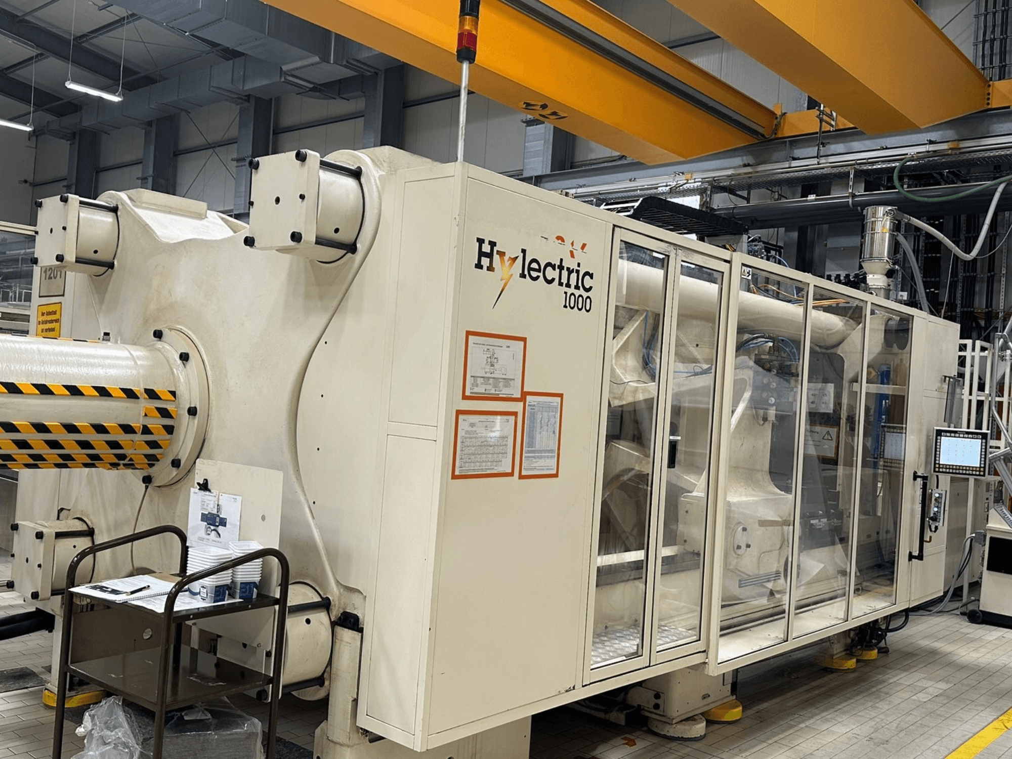Elektryczna wtryskarka Husky Hylelectric H1000 RS95/80, widok z boku z widocznym panelem sterowania i elementami zabezpieczającymi.