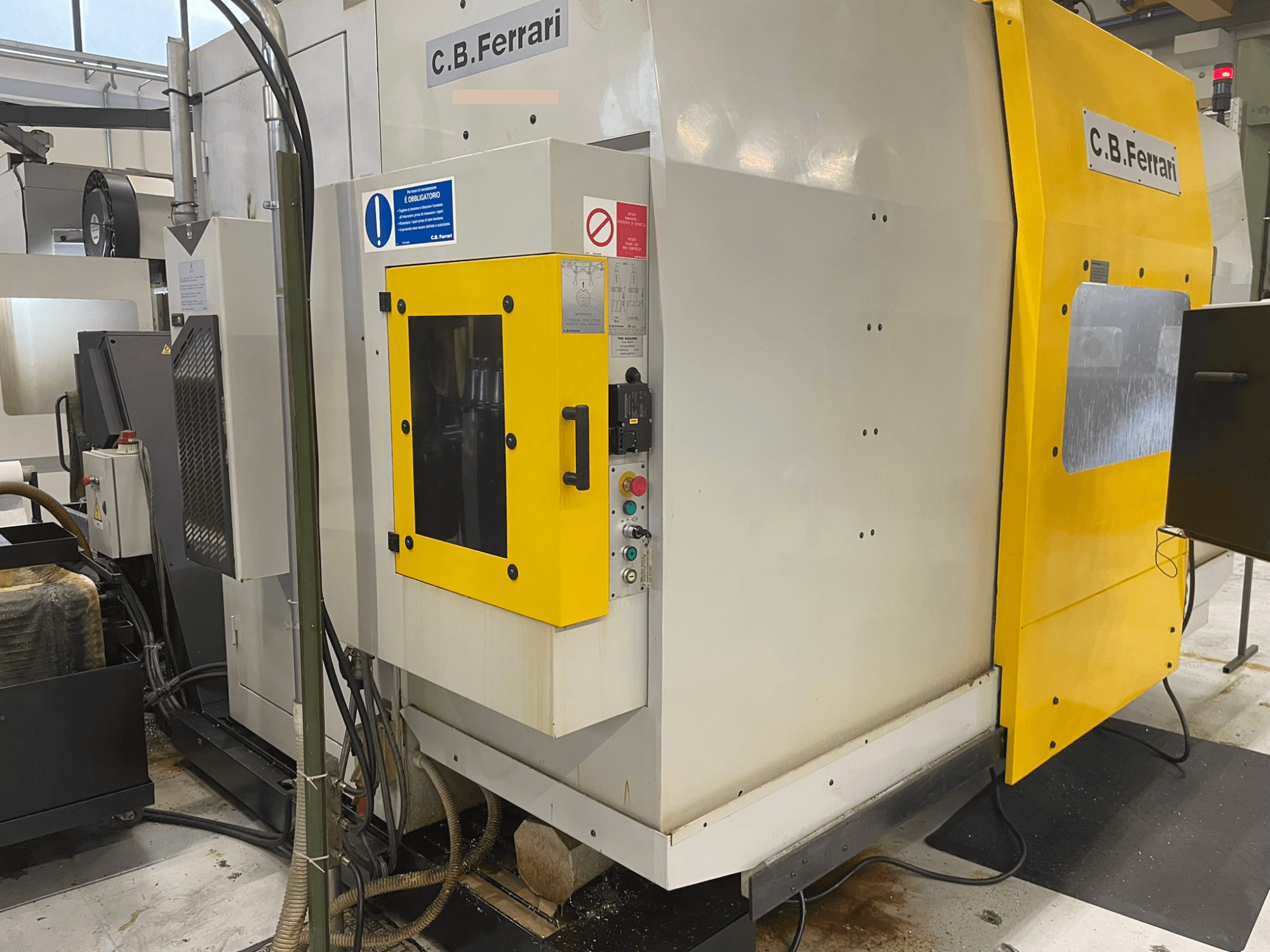 Maszyna przemysłowa C.B. Ferrari, widok z przodu; żółte drzwiczki, panel sterowania i widoczne elementy do obróbki.