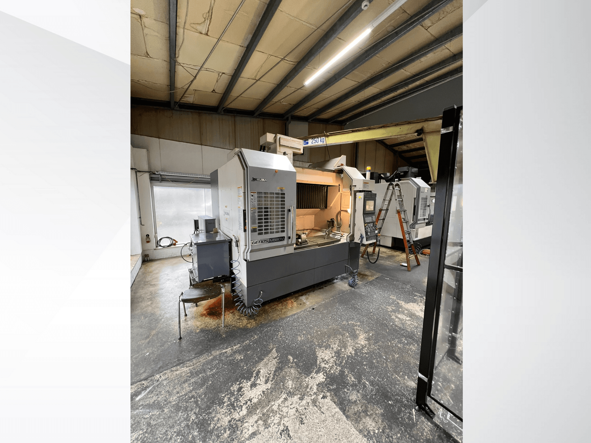 Maszyna CNC GRETOS 750 w warsztacie, widok z przodu, pokazujący panel sterowania i obszar roboczy z narzędziami, widoczna drabina w tle.