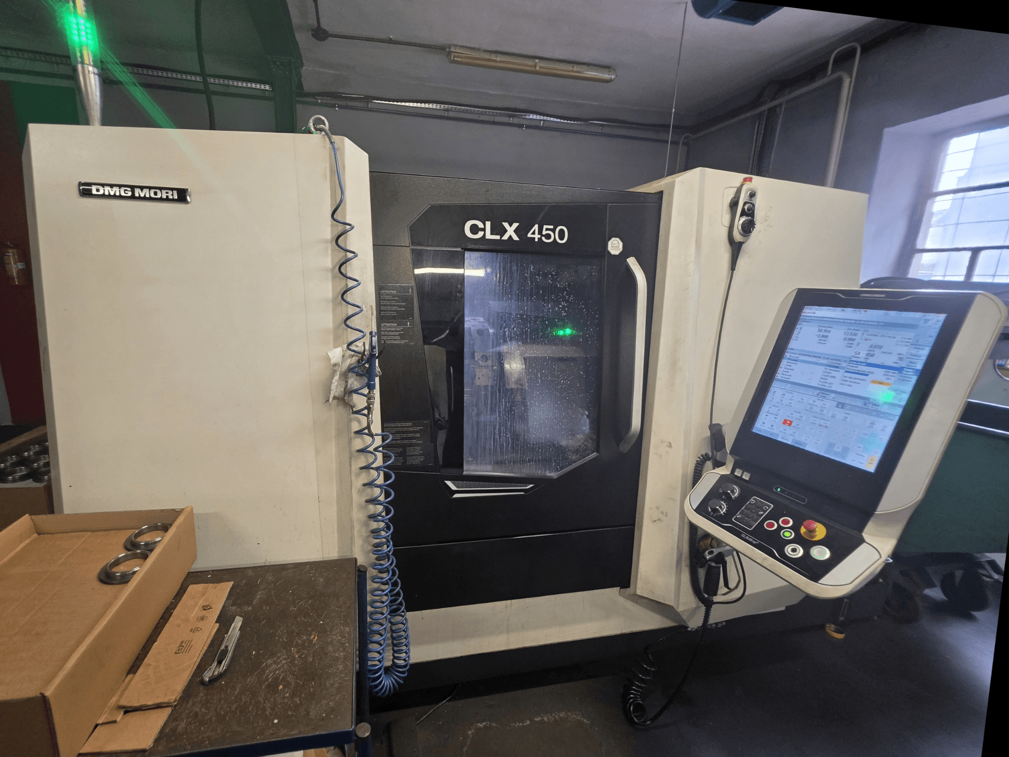 Widok z przodu poziomej tokarki DMG MORI CLX 450 V3 z panelem sterowania, układem chłodzenia i obszarem roboczym.