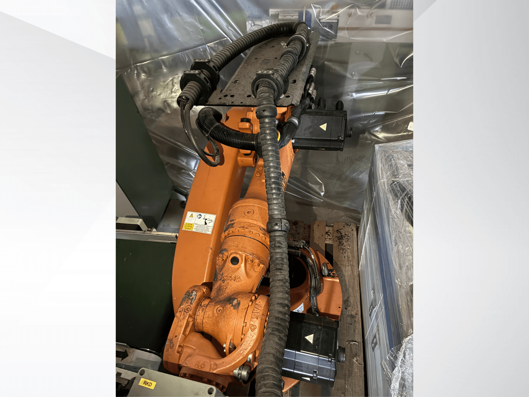 Ramię robota KUKA KR16-2 w kolorze pomarańczowym, widok z góry, z widocznymi złączami i rurkami ochronnymi.