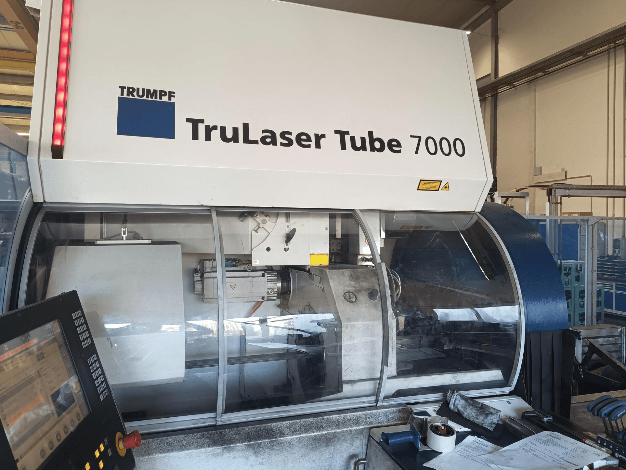 TRUMPF TruLaser Tube 7000, widok maszyny z przodu z panelem sterowania, prezentacja funkcji cięcia laserowego i obszaru roboczego.