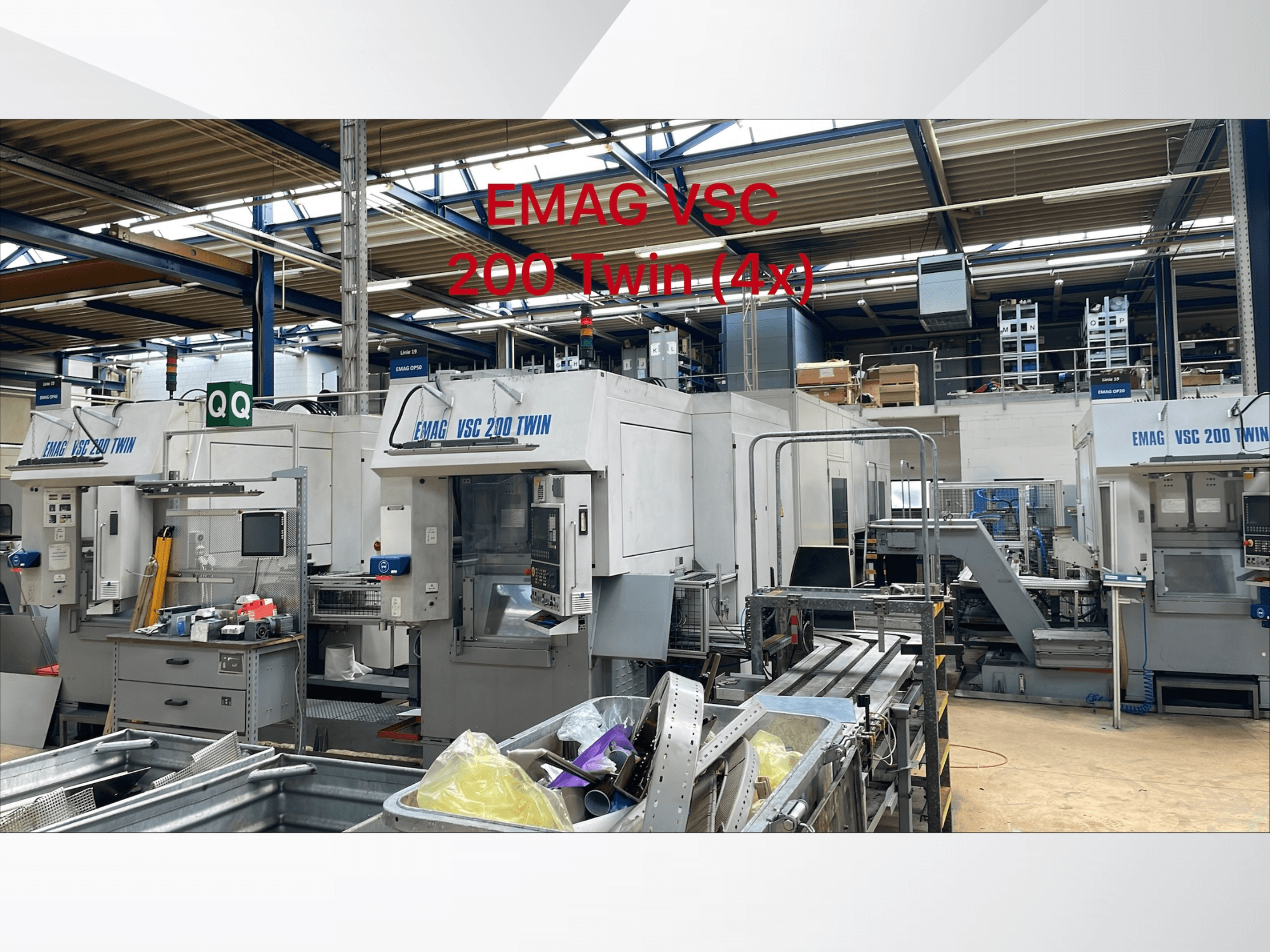 Tokarka pionowa EMAG VSC 200 TWIN OP 40 w fabryce, widok z przodu prezentujący wiele jednostek i urządzeń.