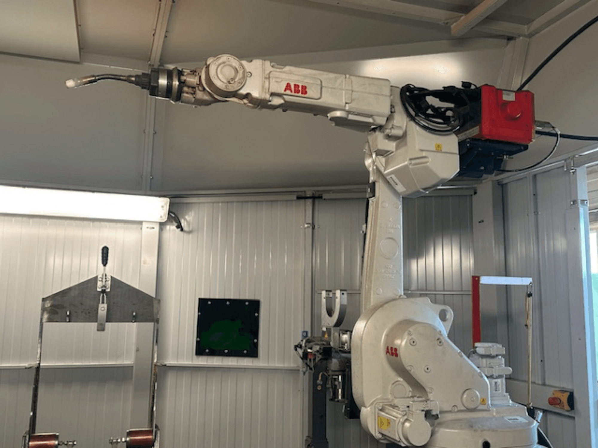 ABB Schweißroboter Flex Arc - widok z boku zrobotyzowanego ramienia z narzędziem spawalniczym, pokazujący szczegóły, takie jak panel sterowania i kable.