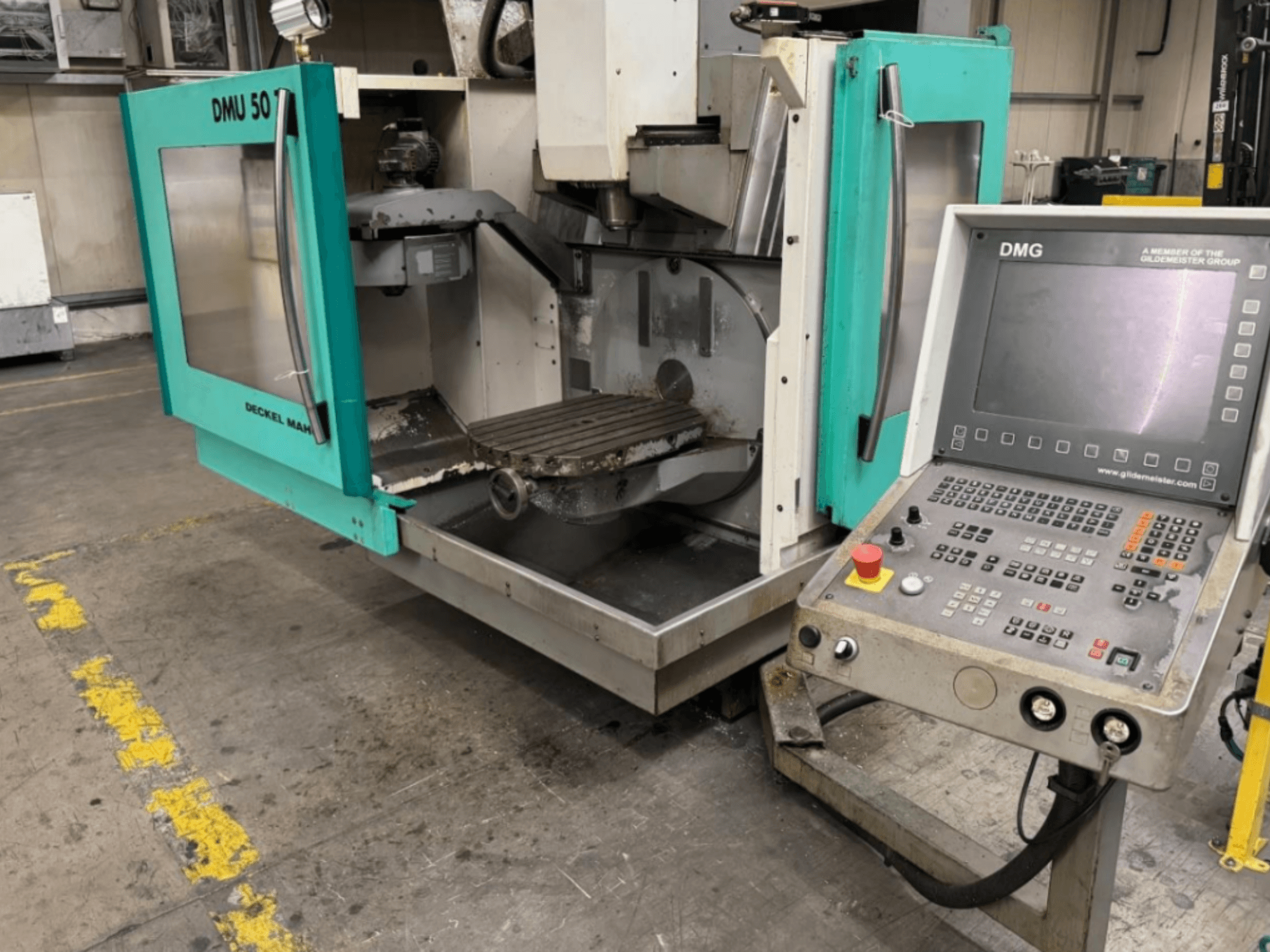 Frezarka DMG DMU 50 z otwartymi drzwiami przedstawiającymi wnętrze i panel sterowania, widziane od przodu.